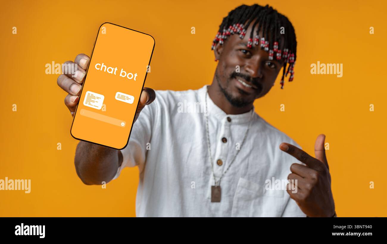 Man showcasing chatbot application on mobile device against vibrant orange backdrop Stock Photo