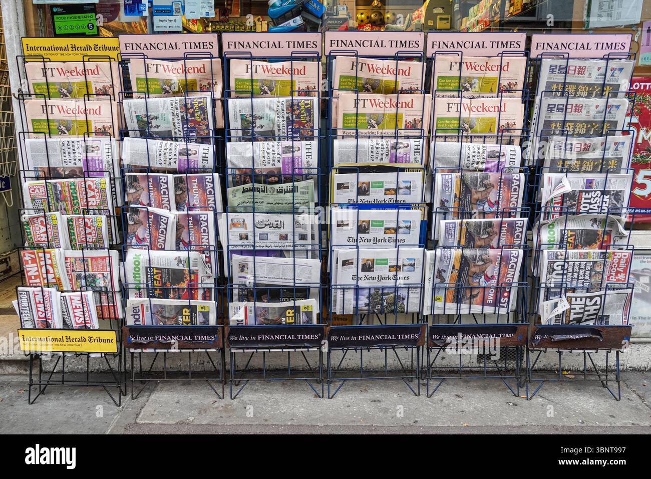 Rack with newspapers outside newsagent's shop in London England United Kingdom UK Stock Photo