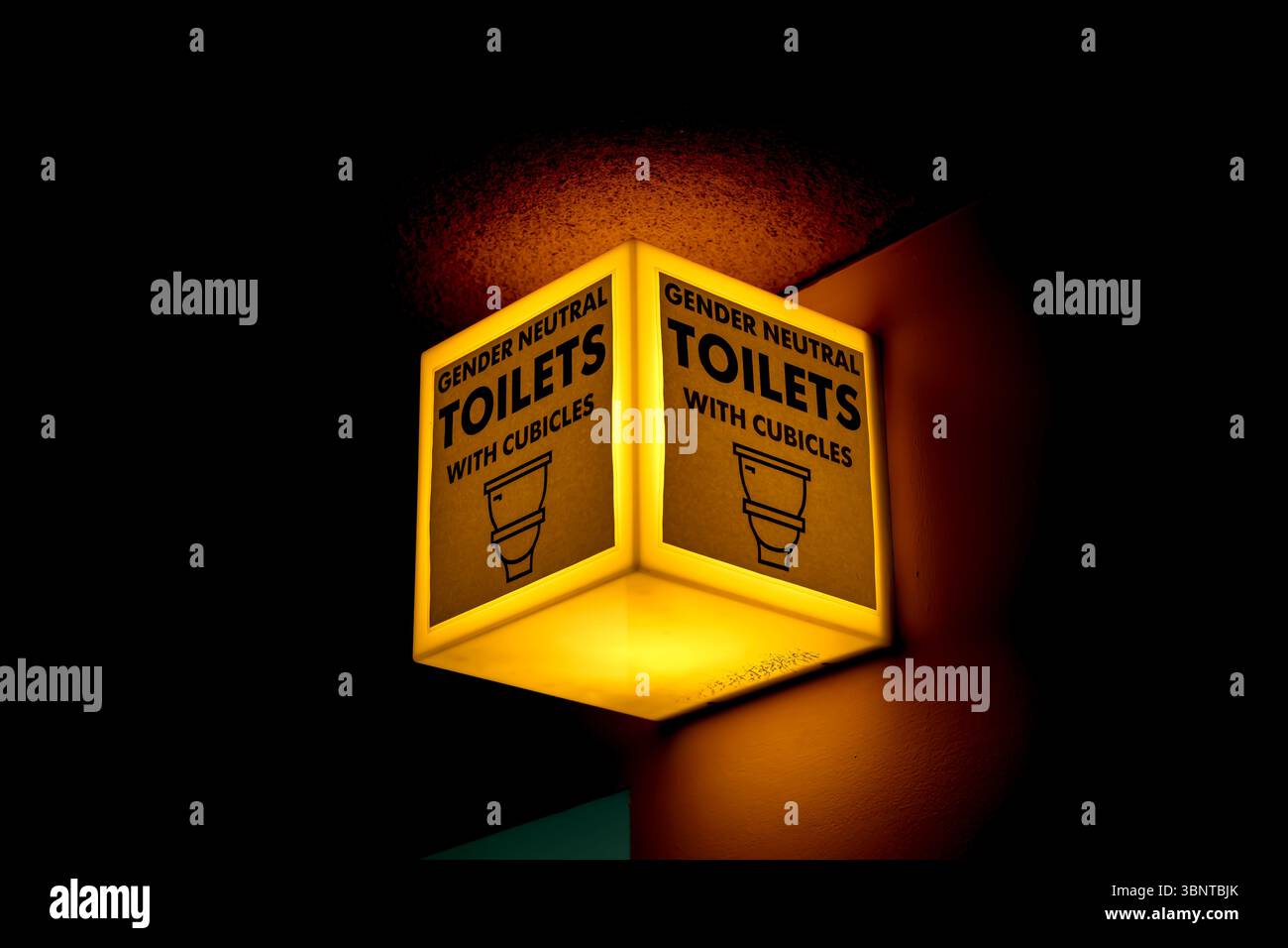 Gender neutral toilets illuminated sign with cubicles Stock Photo
