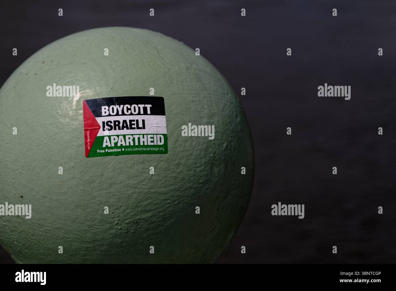 Sticker on a railing ball head over the River Thames reading "Stop Israeli ApartHeid" Stock Photo