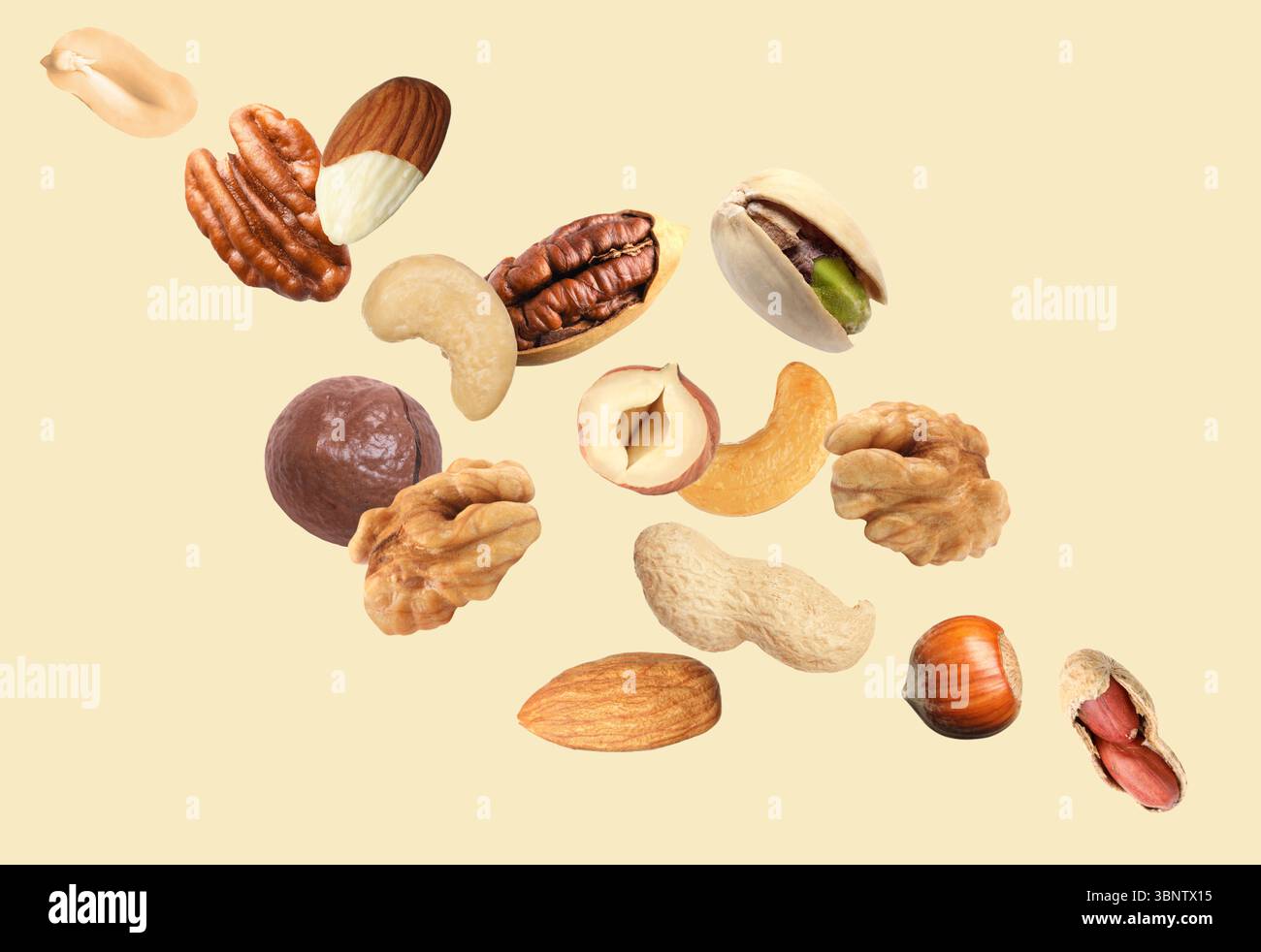 Peanut and other nuts flying on beige background Stock Photo