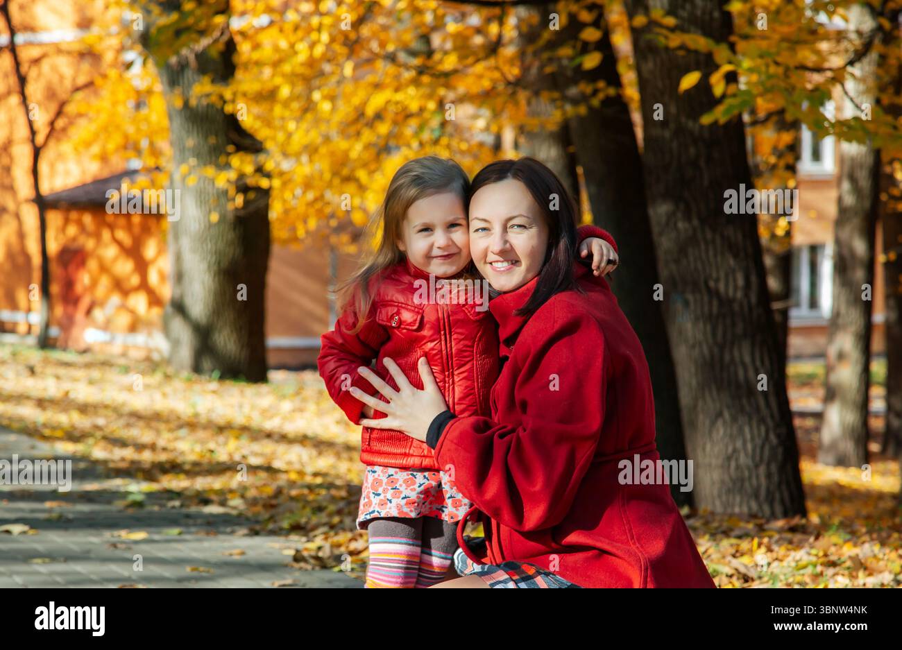 Mother and daughter enjoying sunny autumn day in the park. Family togetherness and fall leisure concept Stock Photo