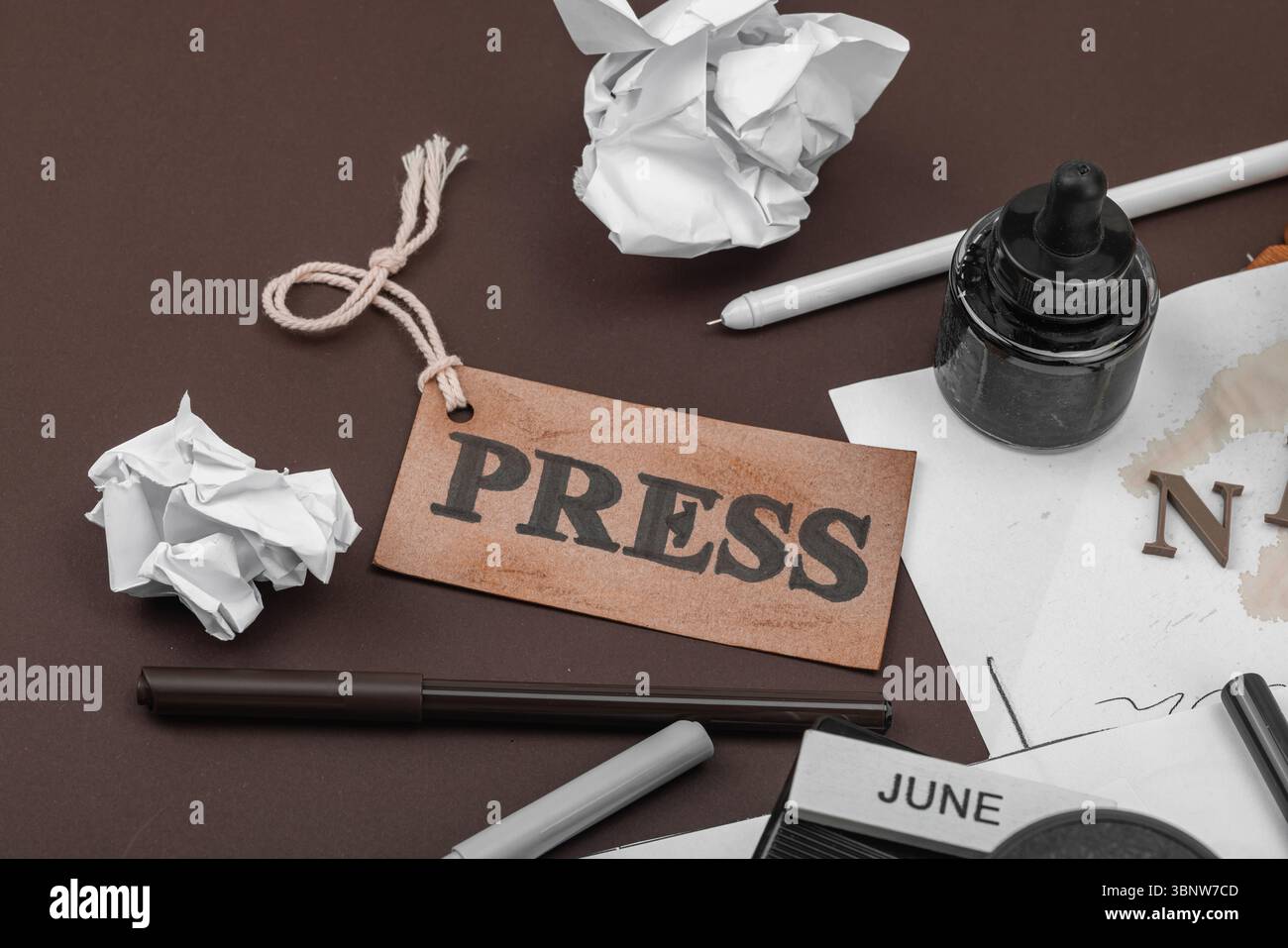 Creative flat lay with vintage camera, press tag, ink bottle, spilled ...