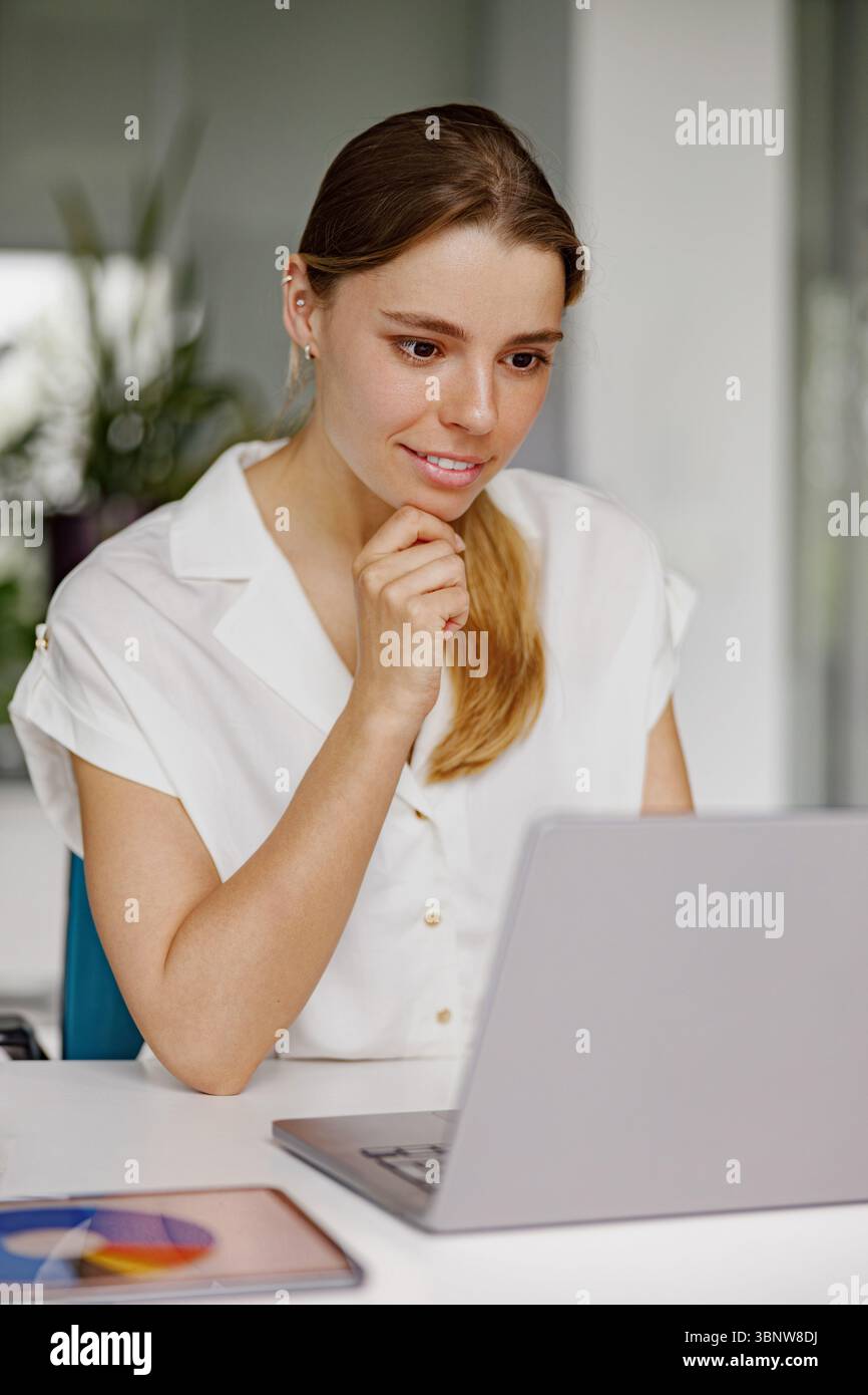 A Dedicated and Professional Woman Actively Engaged in Virtual Work Environments and Activities Stock Photo