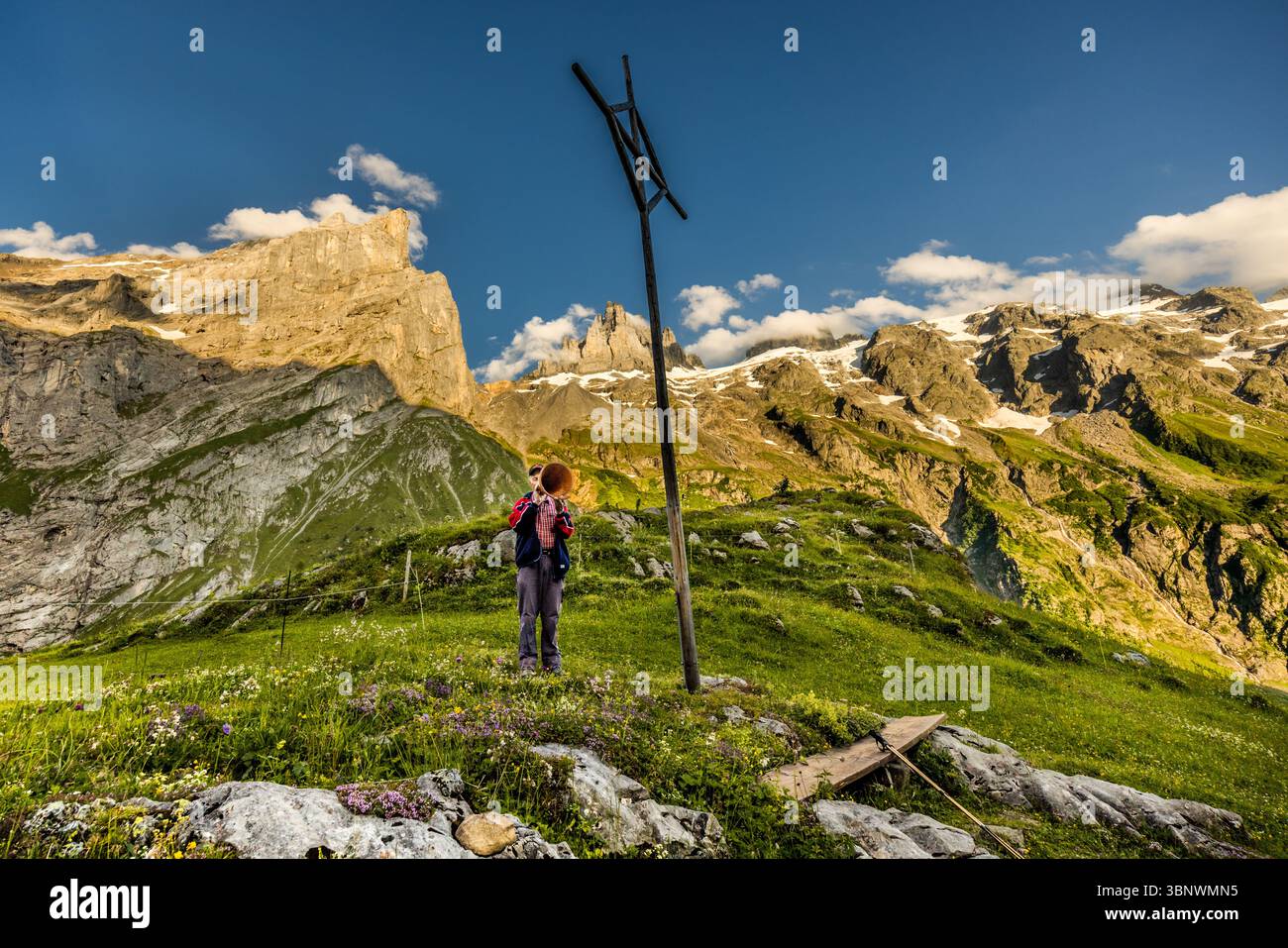 Sepp Zurfluh took over the Hobiel Alp from his father in 1970. He has already spent 69 summers here. In the evening, he calls out the Alpsegen, also known as the Betruf, in all four directions for comprehensive protection from danger. Evening ritual in the alpine landscape at the Hobiel-Alp, near Engelberg, Switzerland. The eldest family member performs the traditional call to prayer in front of all those present. This tradition shows the combination of deep piety and the impressive nature of the Swiss Alps. Hobiel, Engelberg, Uri, Switzerland Stock Photo