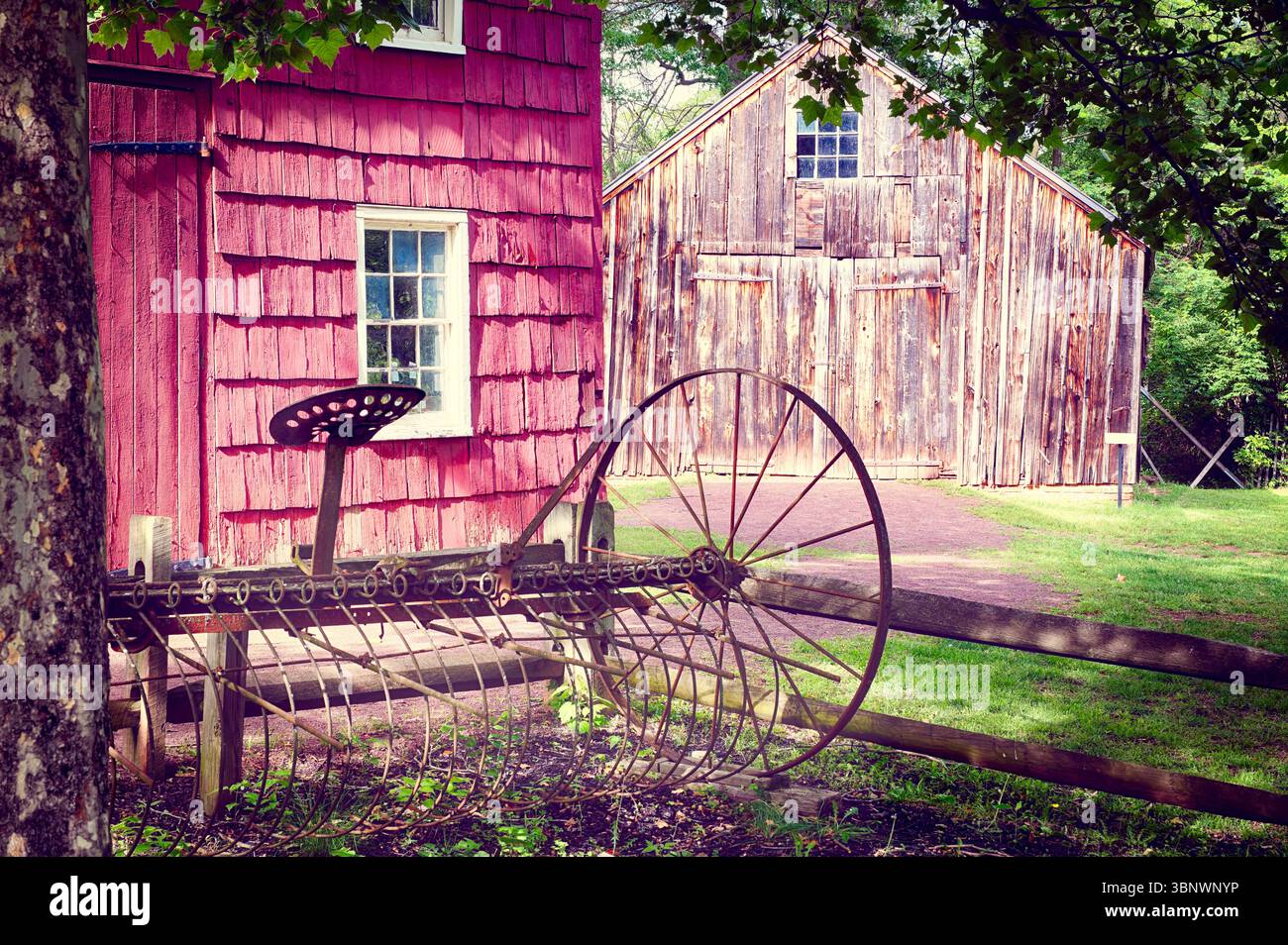 Old Wooden Barn, With a Rusting Tilling Equipment, East Jersey Old Town Village, Piscataway, New Jersey, USA Stock Photo