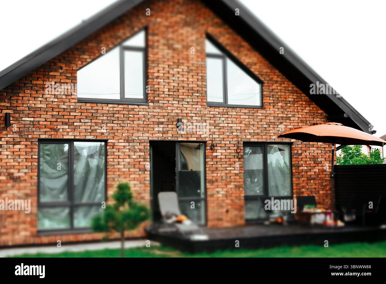 Modern brick house featuring a patio, outdoor living spaces. A cozy ...