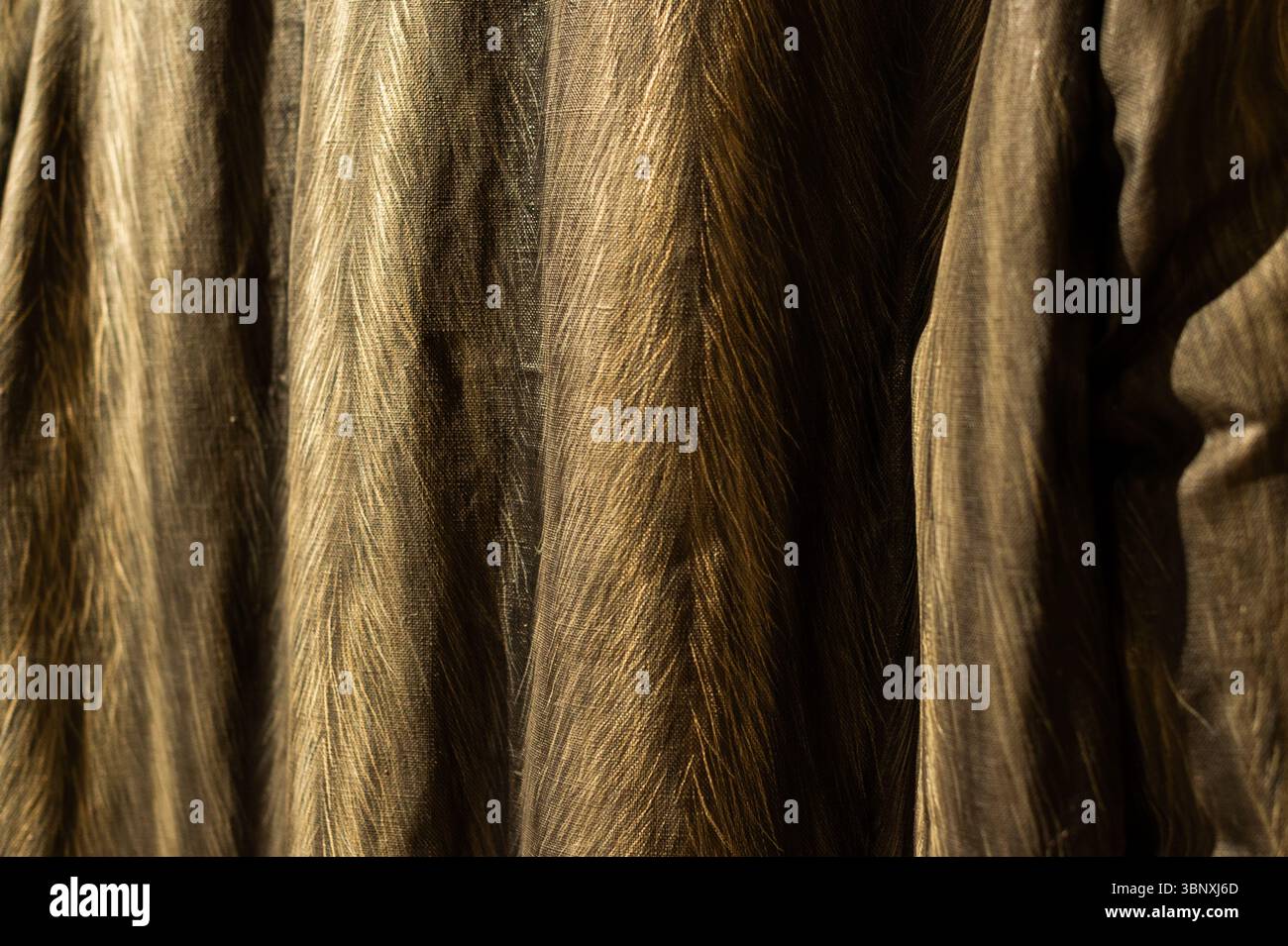 Elegant fabric texture with subtle vertical stripes in warm brown and gold tones. Ideal for fashion, textile, and abstract backgrounds. Stock Photo