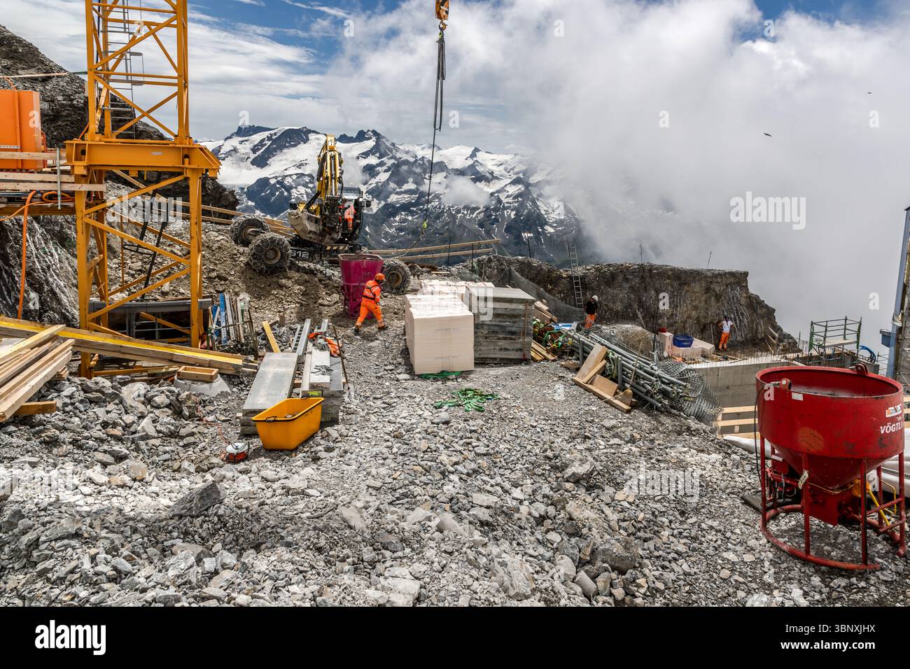 One of the highest construction sites in the Alps in 2025: The major project 'Titlis 3020' involves the construction of a new mountain station at an altitude of 3,020 metres and the expansion of other infrastructure, such as a new cable car and shops selling luxury goods. The construction work on the edge of the glacier and in high alpine terrain has led to protests from environmentalists. Construction workers carry out challenging building work on the Titlis in Engelberg, Obwalden, Switzerland. A crane and an excavator are used to move materials in the rocky high mountain landscape. The work  Stock Photo
