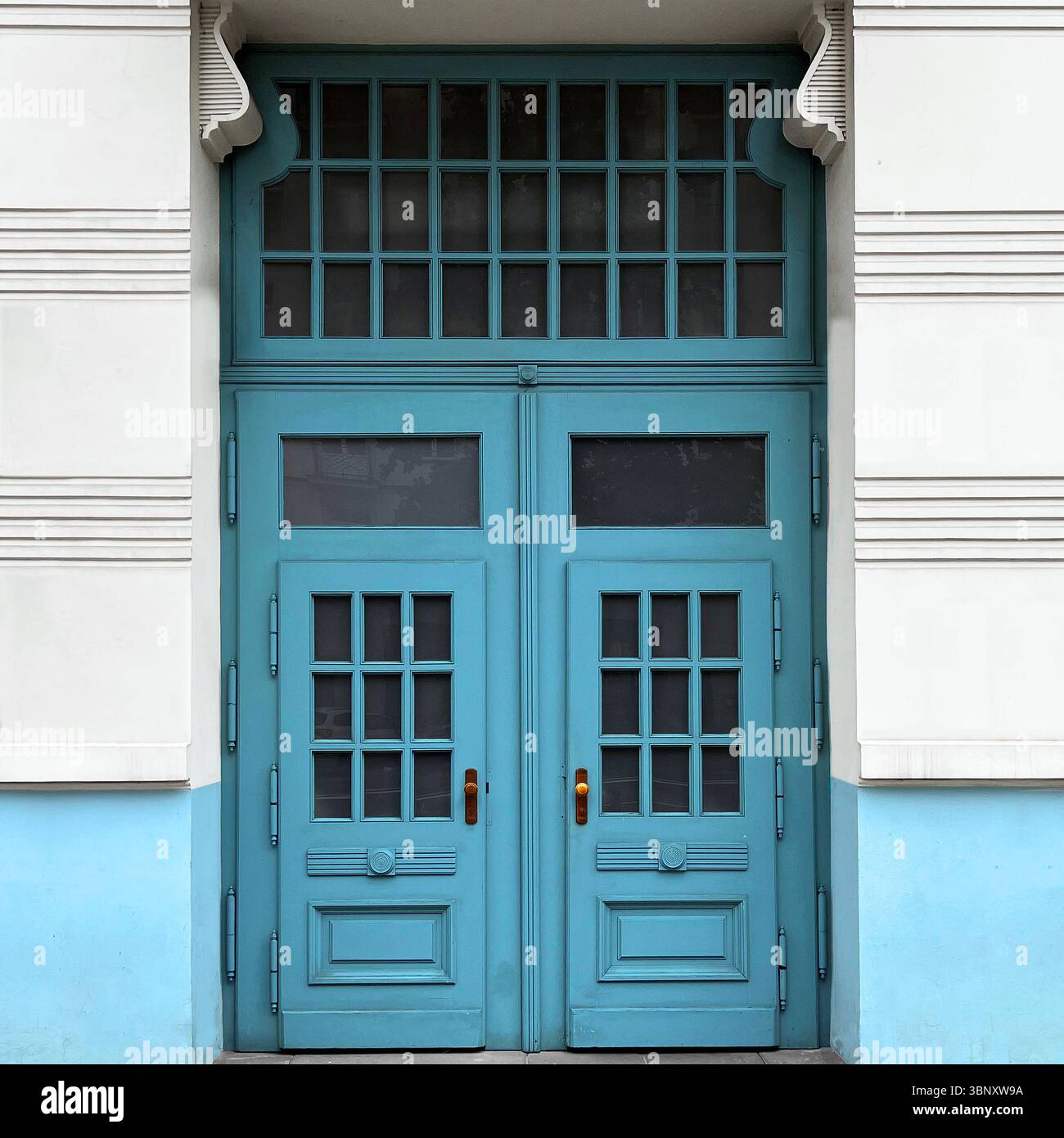 A striking blue double door in Warsaw, Poland, blends geometric glass panels and symmetrical detailing against a two-tone modernist facade. - Smartphone Captured Stock Image