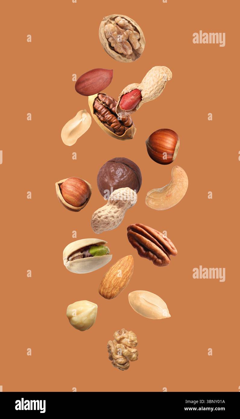Peanut and other nuts falling on brown background Stock Photo