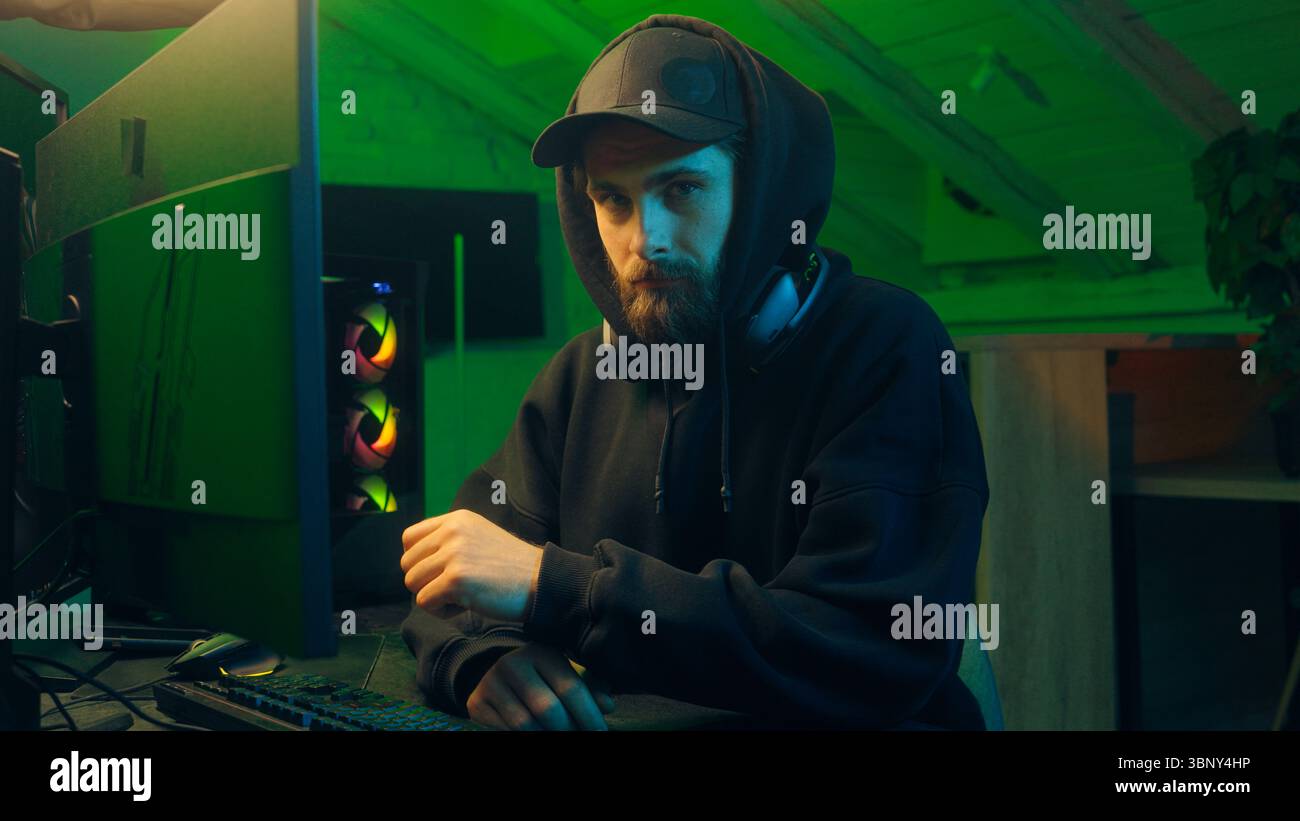 Caucasian man hacker computer looking at camera programming pc scam networking male guy spying thief virtual dangerous criminal coding web Stock Photo