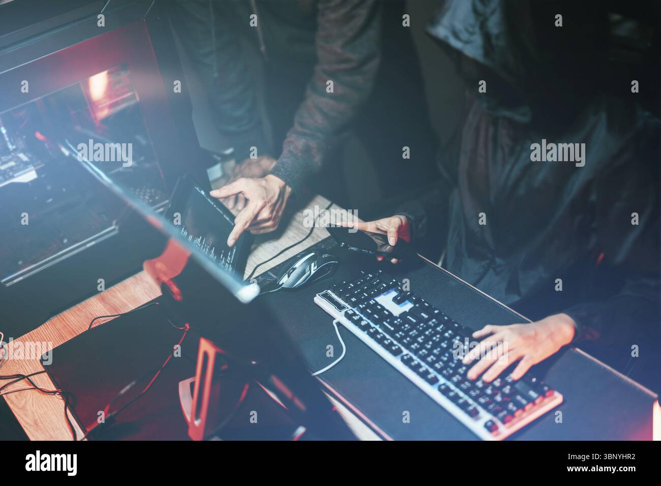 Hacker in dark room using keyboard stealing data on internet Stock Photo