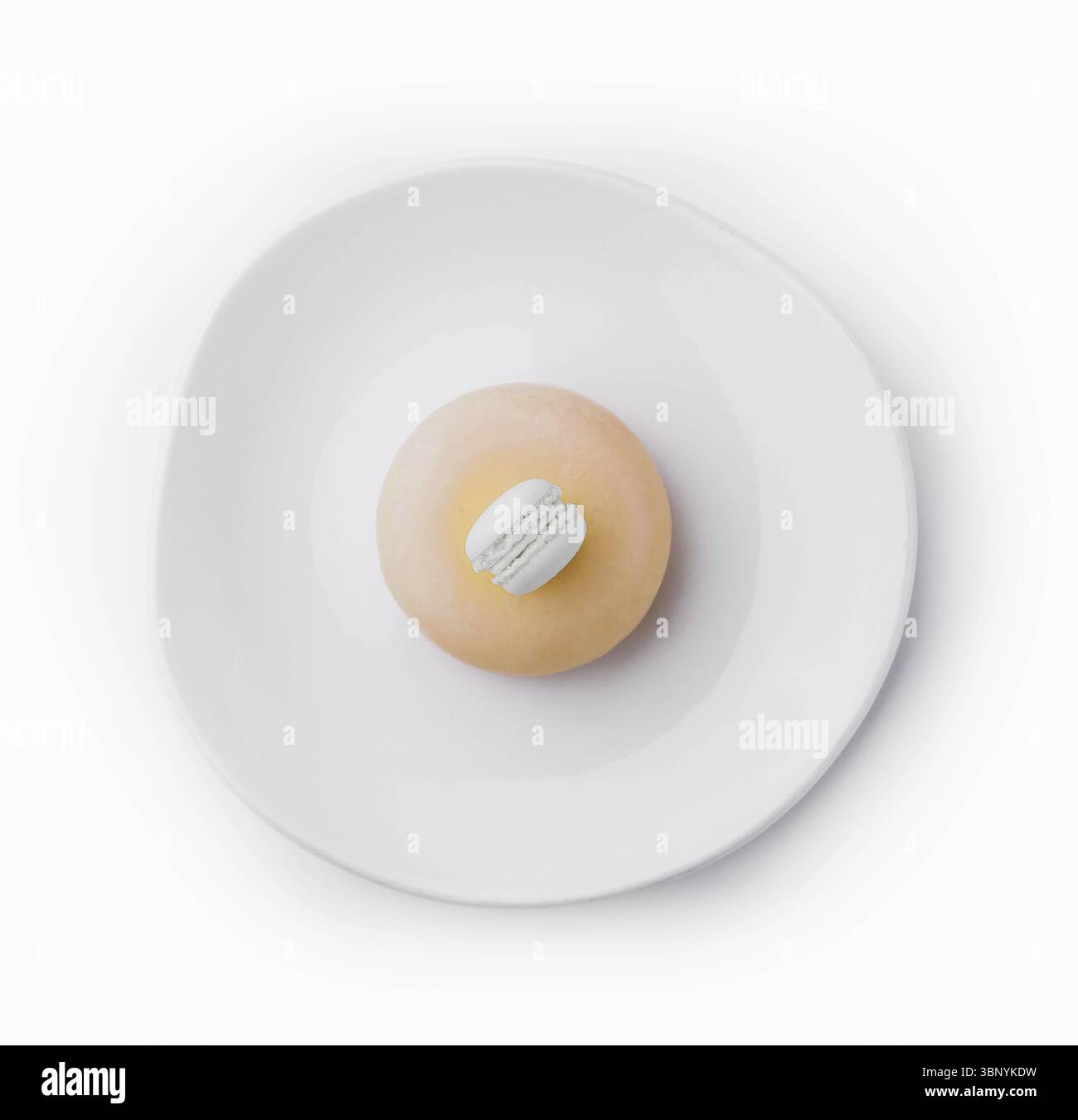 Yellow mousse cake decorated with white macaroon Stock Photo