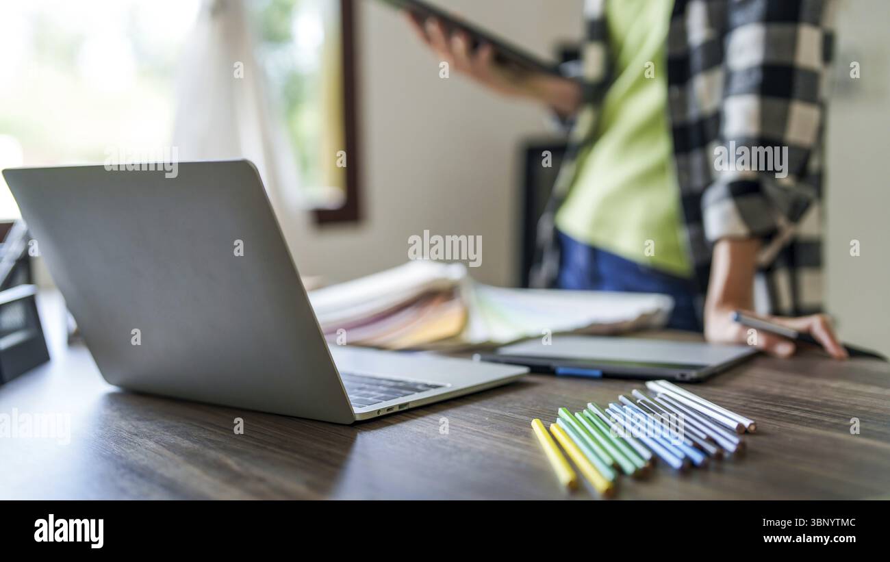 Creative designer using digital tablet creating artwork at modern workplace Stock Photo
