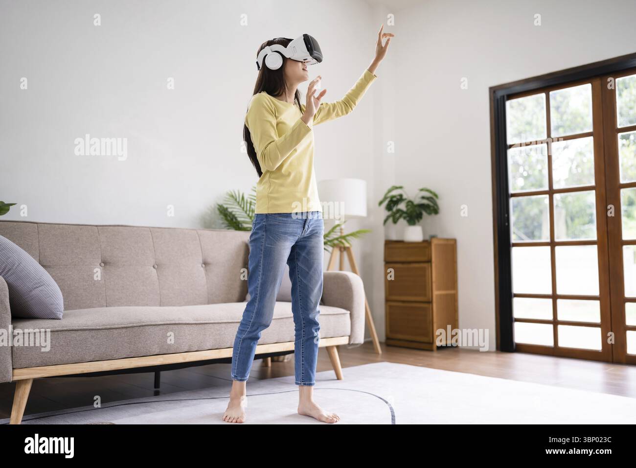 Beautiful young asian woman in glasses of virtual reality technology VR ...