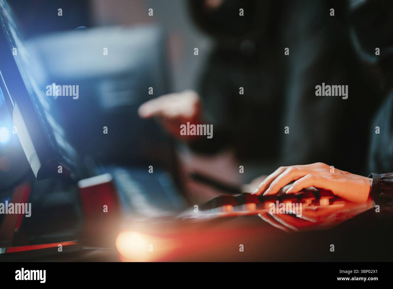 Hacker in dark room using keyboard stealing data on internet Stock Photo