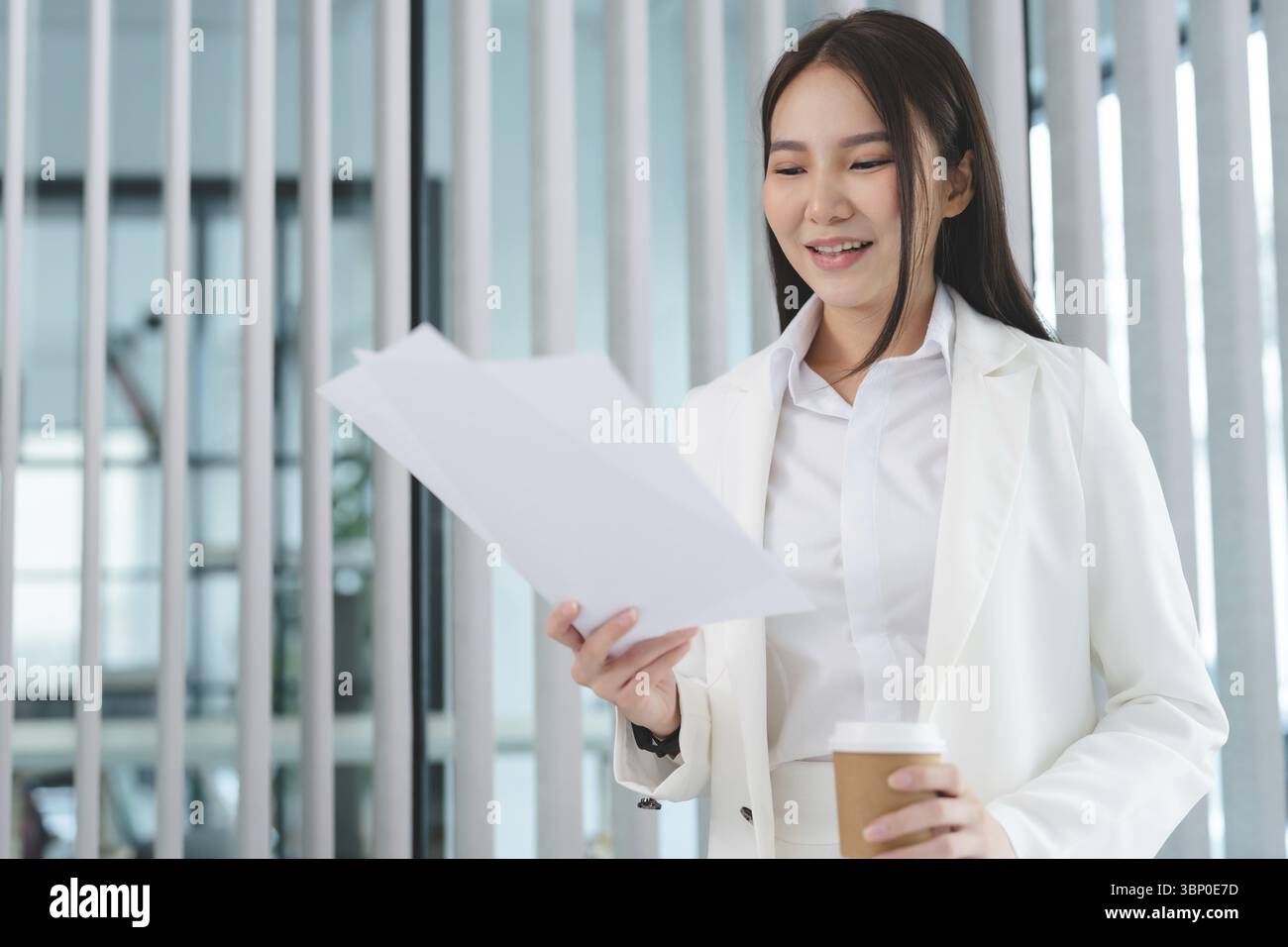 Businesswoman working with documents while drinking coffee Stock Photo