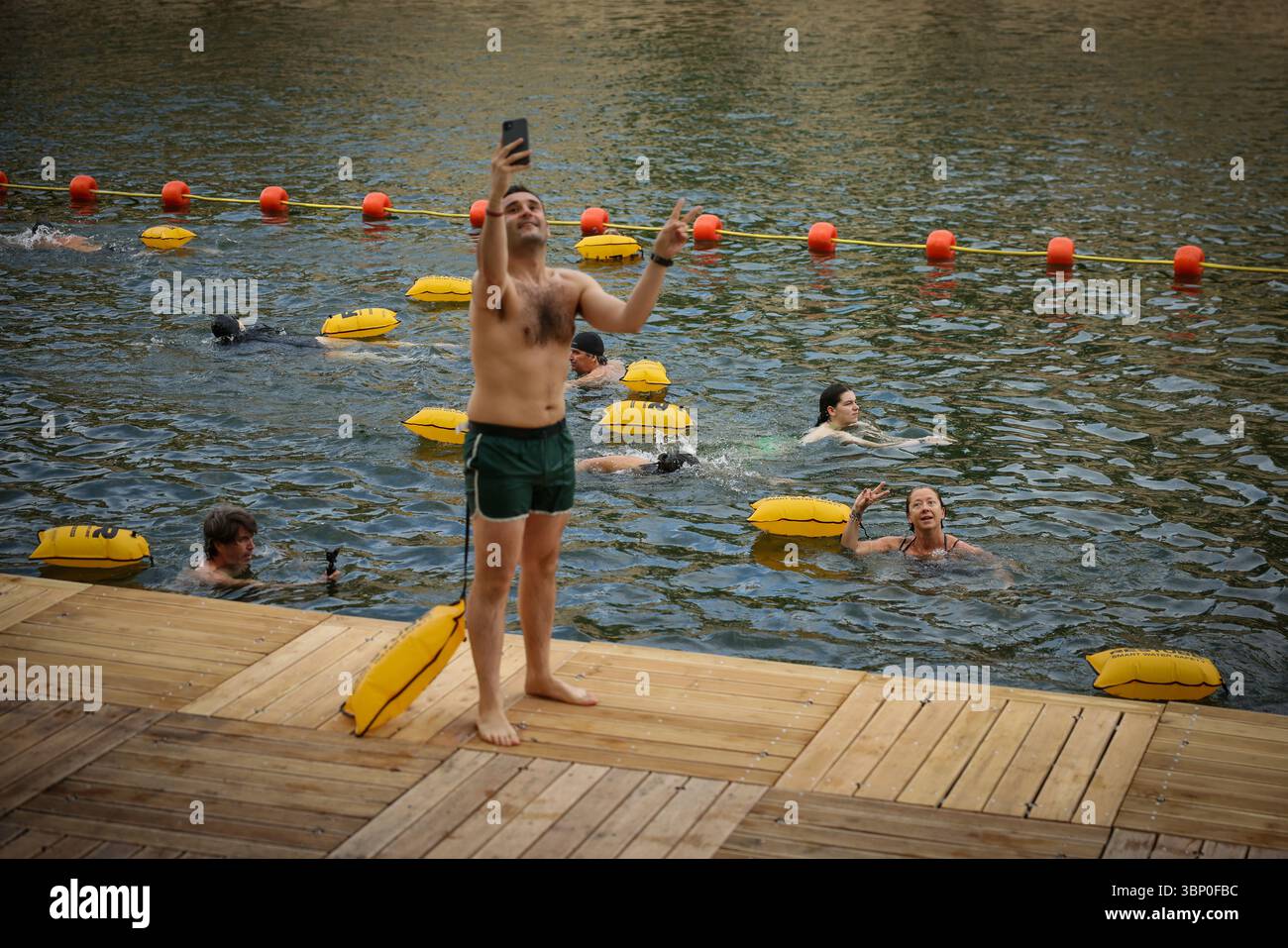 A man pictures himself as people swim at the Bras Marie safe bathing ...