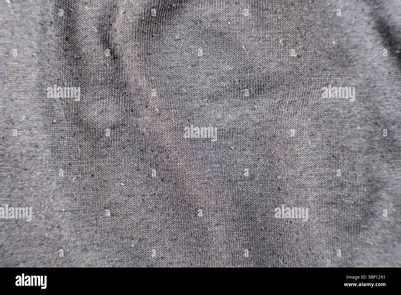 Old worn-out cotton fabric, pilling on a surface. Stock Photo