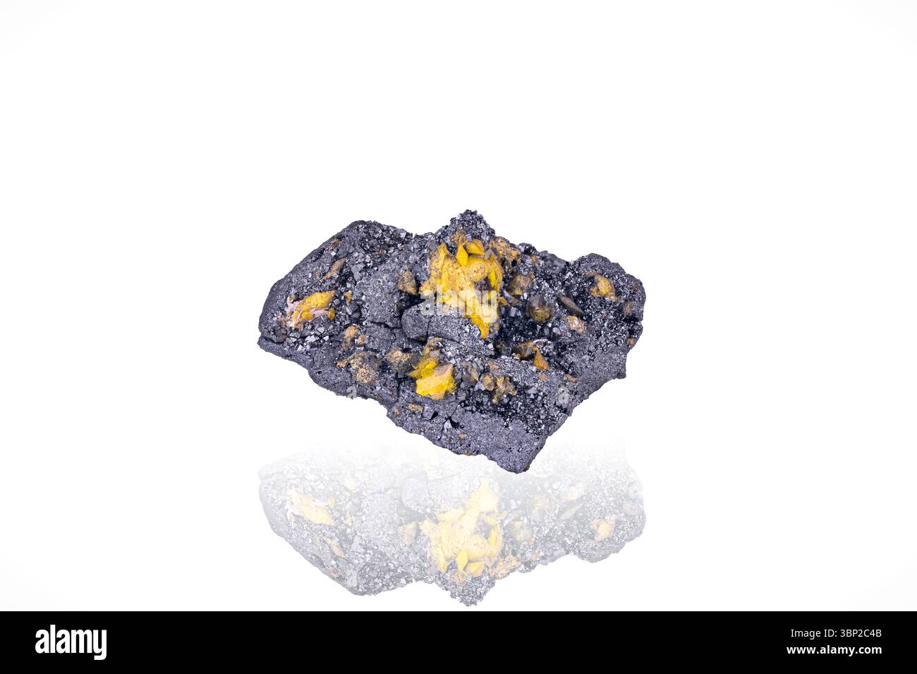 Yellow Sturmanite on black Manganite. Specimen from N'Chwaning 2, South Africa. photography isolated on white blackground. macro detail background. Stock Photo
