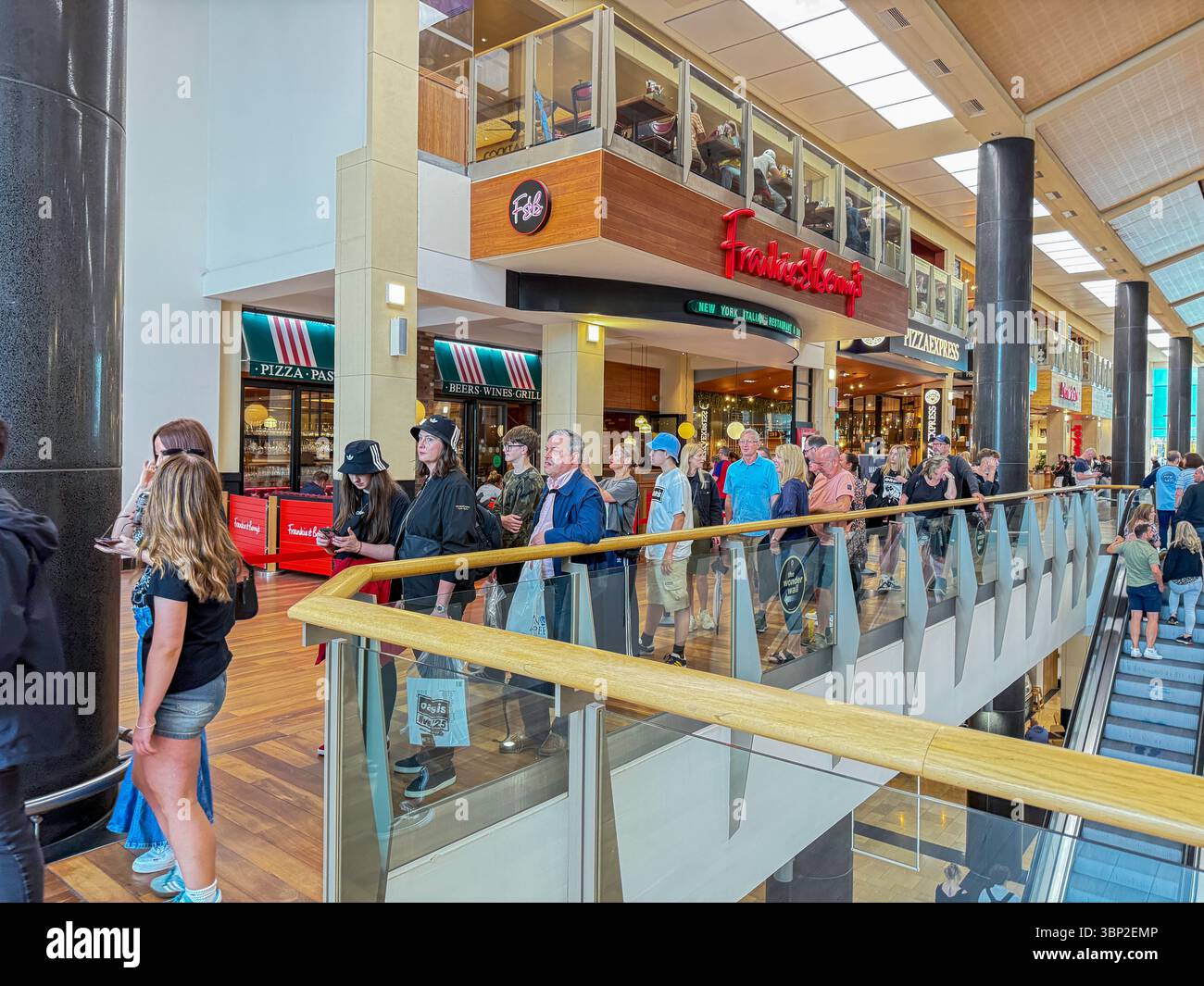 Oasis Fans Posing for Group Photo at Wonder Wall Display, St David’s 2 Shopping Centre Cardiff on the Oasis Live '25 tour, Wales - Smartphone Captured Stock Image
