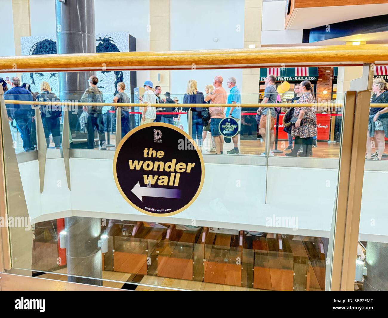 Oasis Fans Posing for Group Photo at Wonder Wall Display, St David’s 2 Shopping Centre Cardiff on the Oasis Live '25 tour, Wales - Smartphone Captured Stock Image