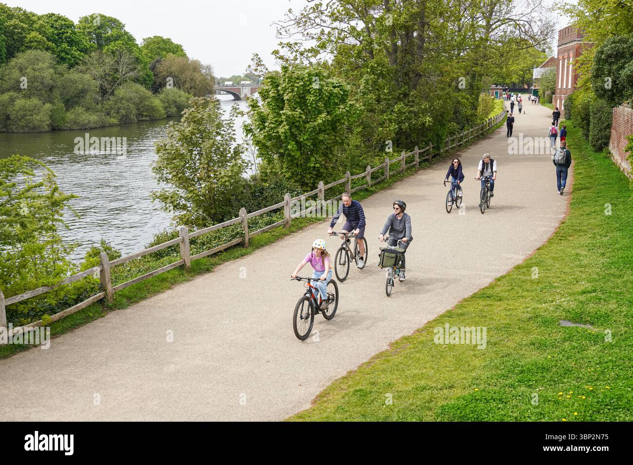 People enjoying sunny spring day on Thames path in Hampton, Richmond upon Thames, London, England United Kingdom UK Stock Photo