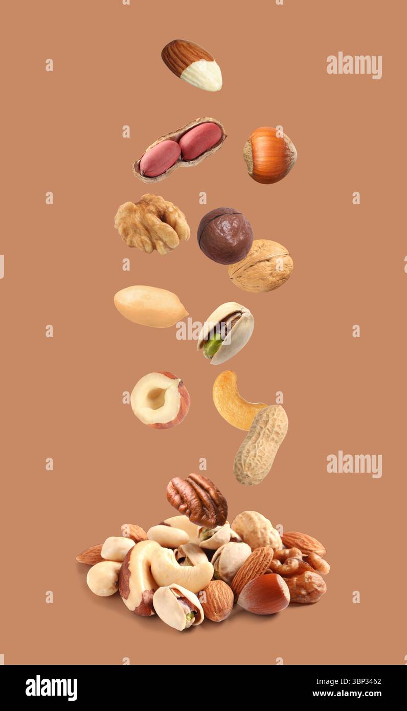 Peanut and other nuts falling on brown background Stock Photo
