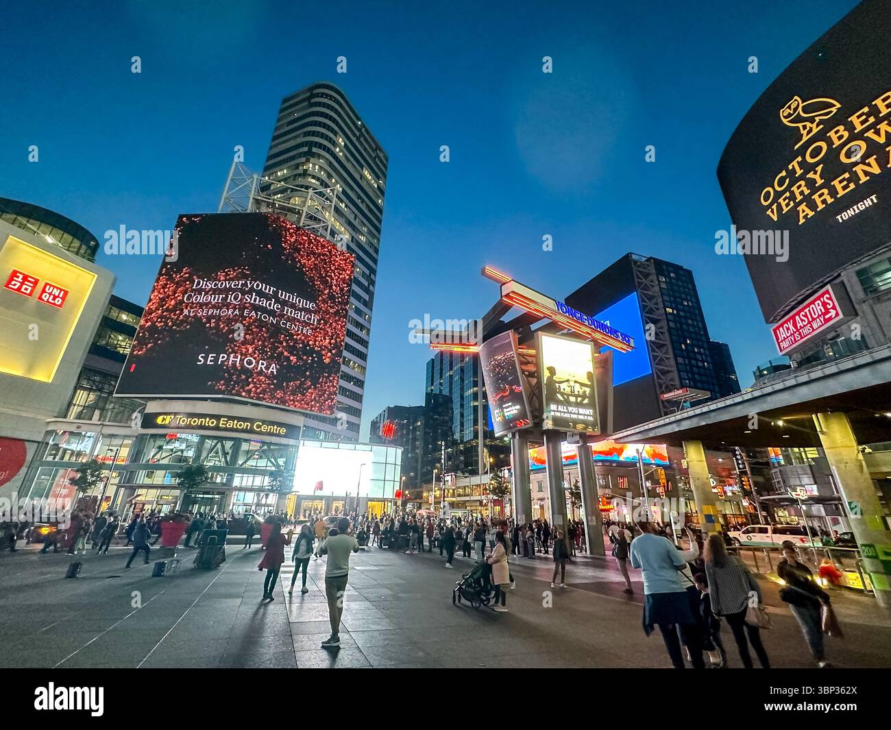 Toronto, Ontario - October 7, 2023: The vibrant nighttime scenery and people gathering at the corner of Yonge Street and Dundas in downtown Toronto Stock Photo