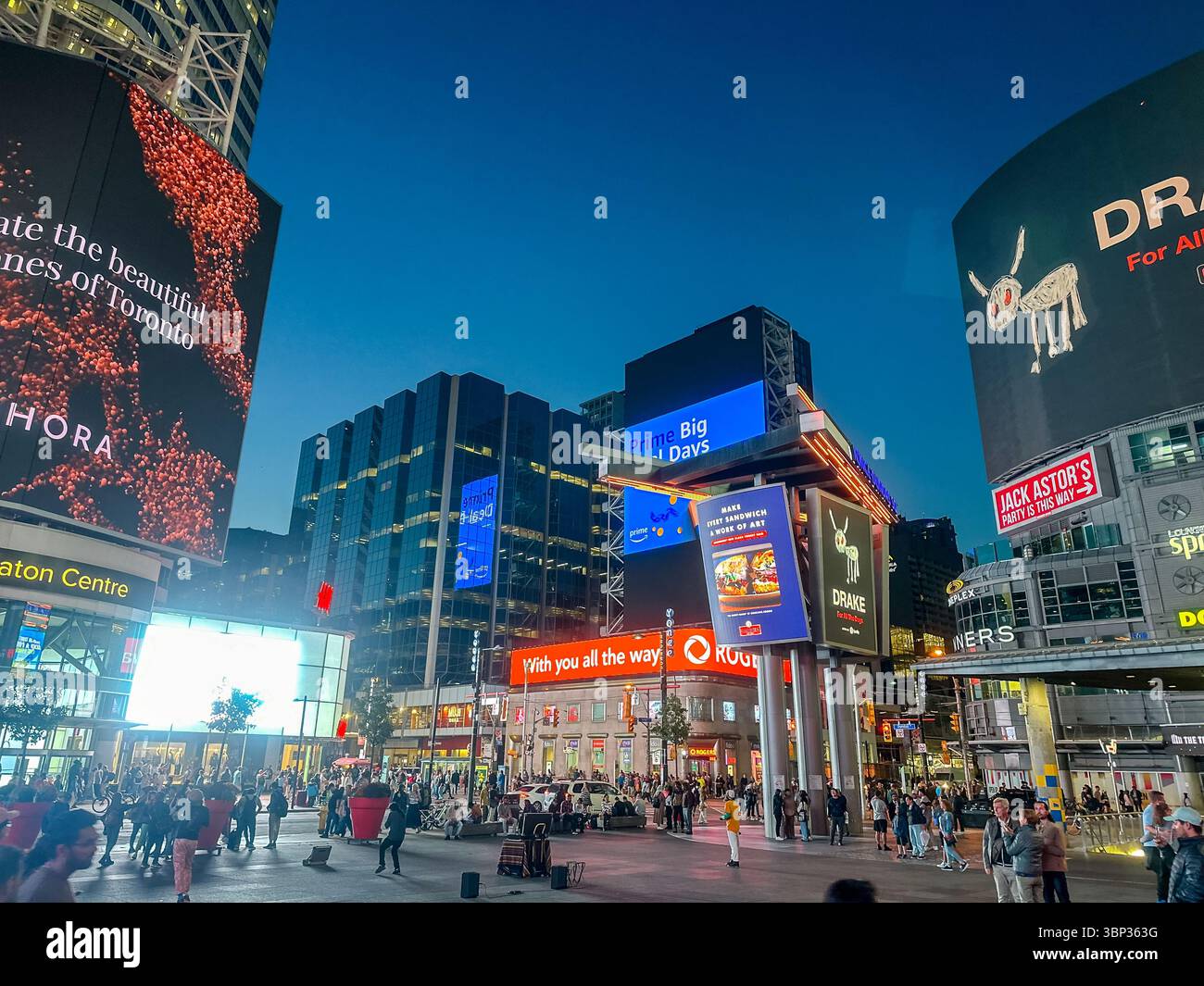 Toronto, Ontario - October 7, 2023: The vibrant nighttime scenery and people gathering at the corner of Yonge Street and Dundas in downtown Toronto Stock Photo