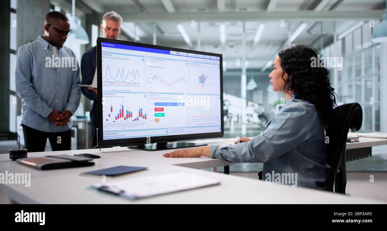 Analyzing Data On KPI Dashboard: A Multicultural Team In Business Stock Photo