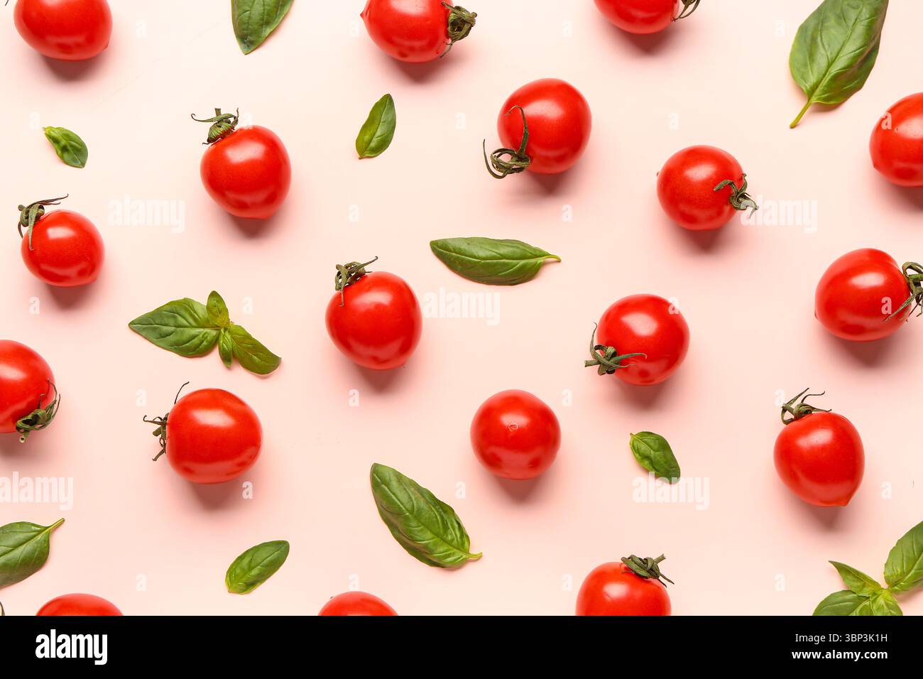 Fresh cherry tomatoes and basil on pink background Stock Photo