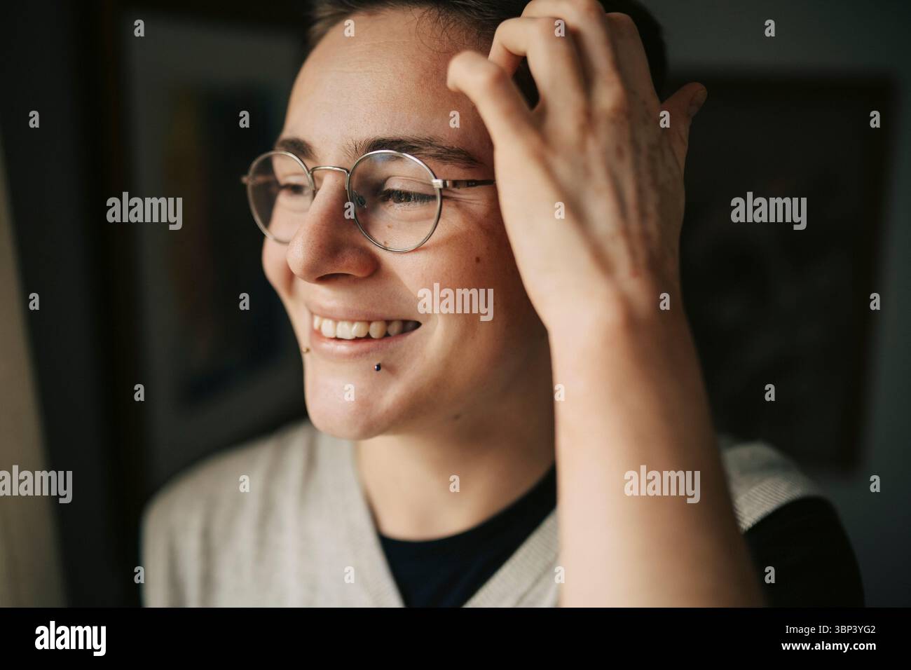 Smiling young man with piercing looking away Stock Photo
