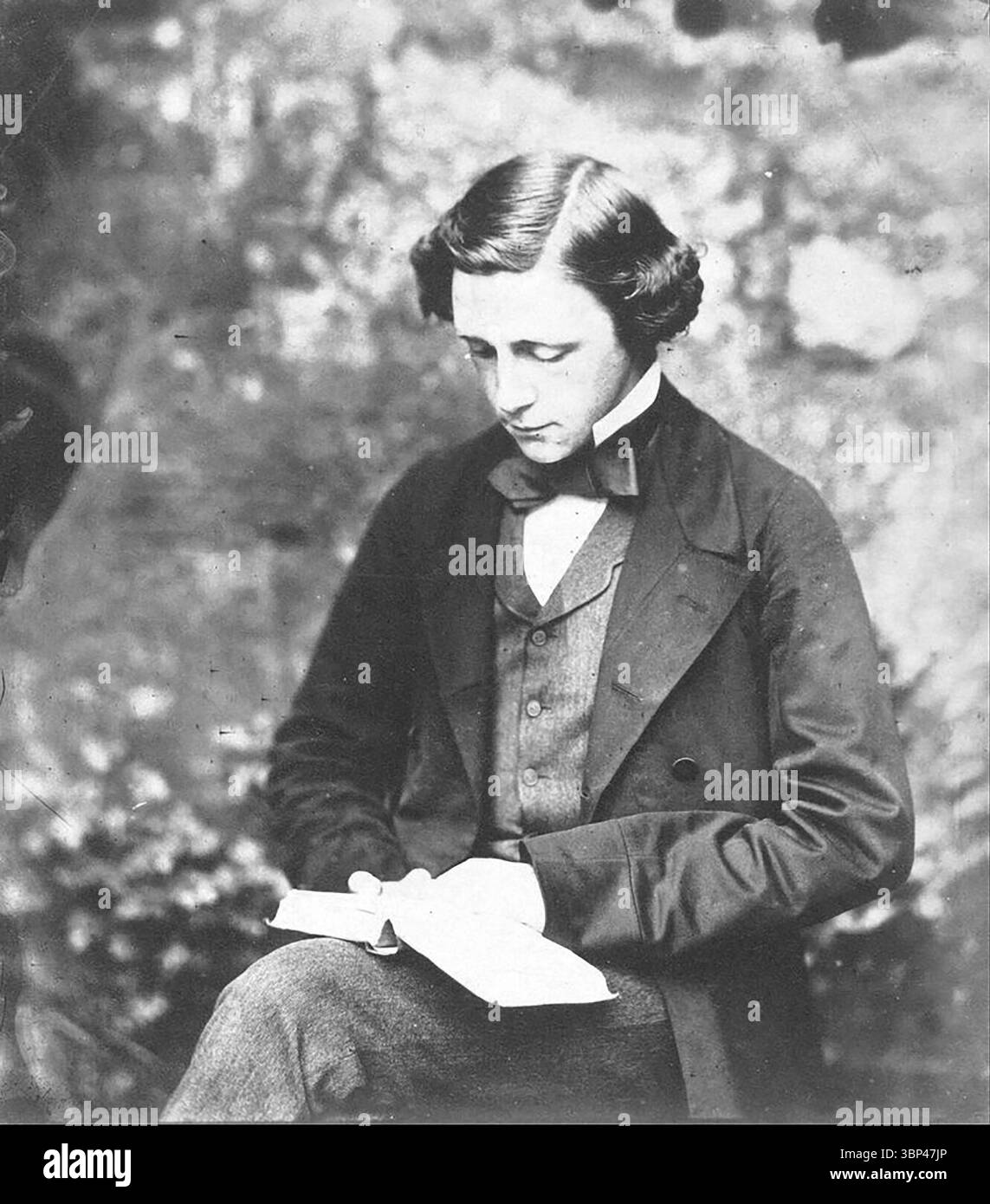 A self-portrait photograph by Lewis Carroll (Charles Lutwidge Dodgson), an English author, poet, mathematician, and photographer, depicting himself reading. 1856. Stock Photo