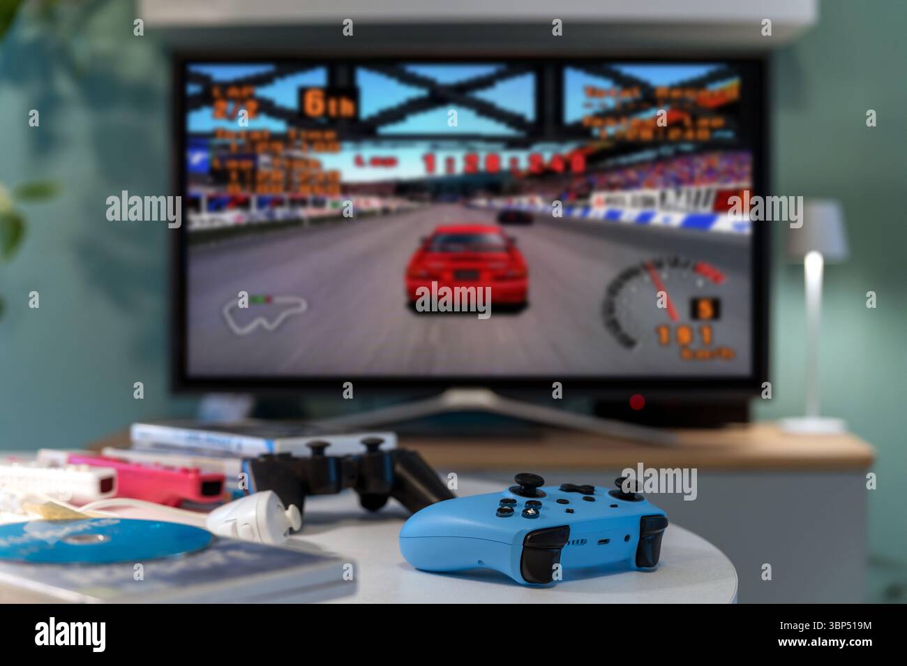 Milan, Lombardy, Italy - February 24, 2025: Blue gamepad on table with retro car racing Gran Turismo videogame running on tv screen in living room Stock Photo