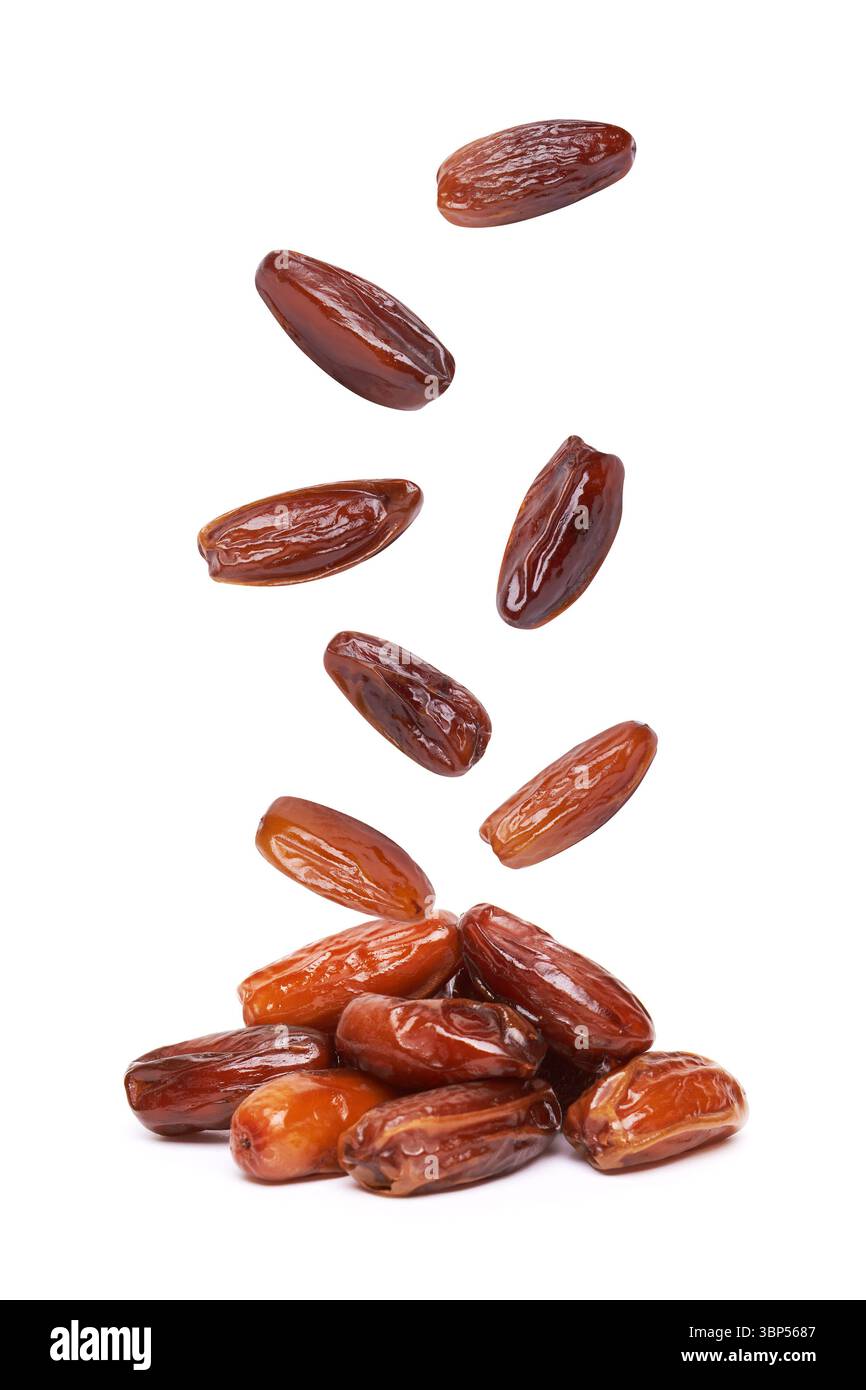 Dried dates fruits falling, isolated on white background Stock Photo
