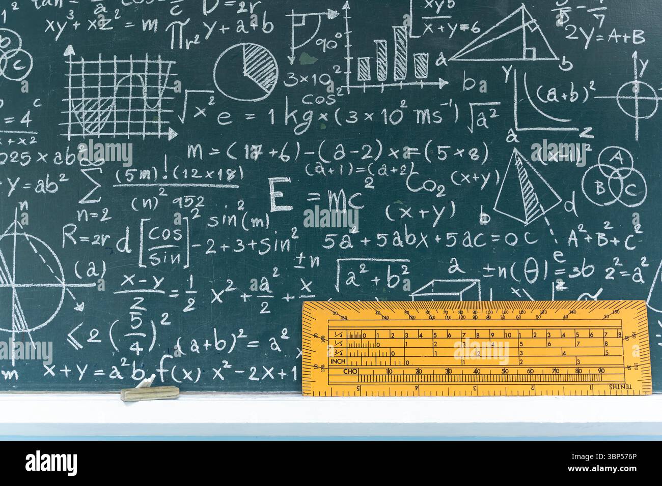 Educational blackboard in classroom filled with math and science formulas, graphs and equations, with yellow measurement ruler tool, concept of learni Stock Photo