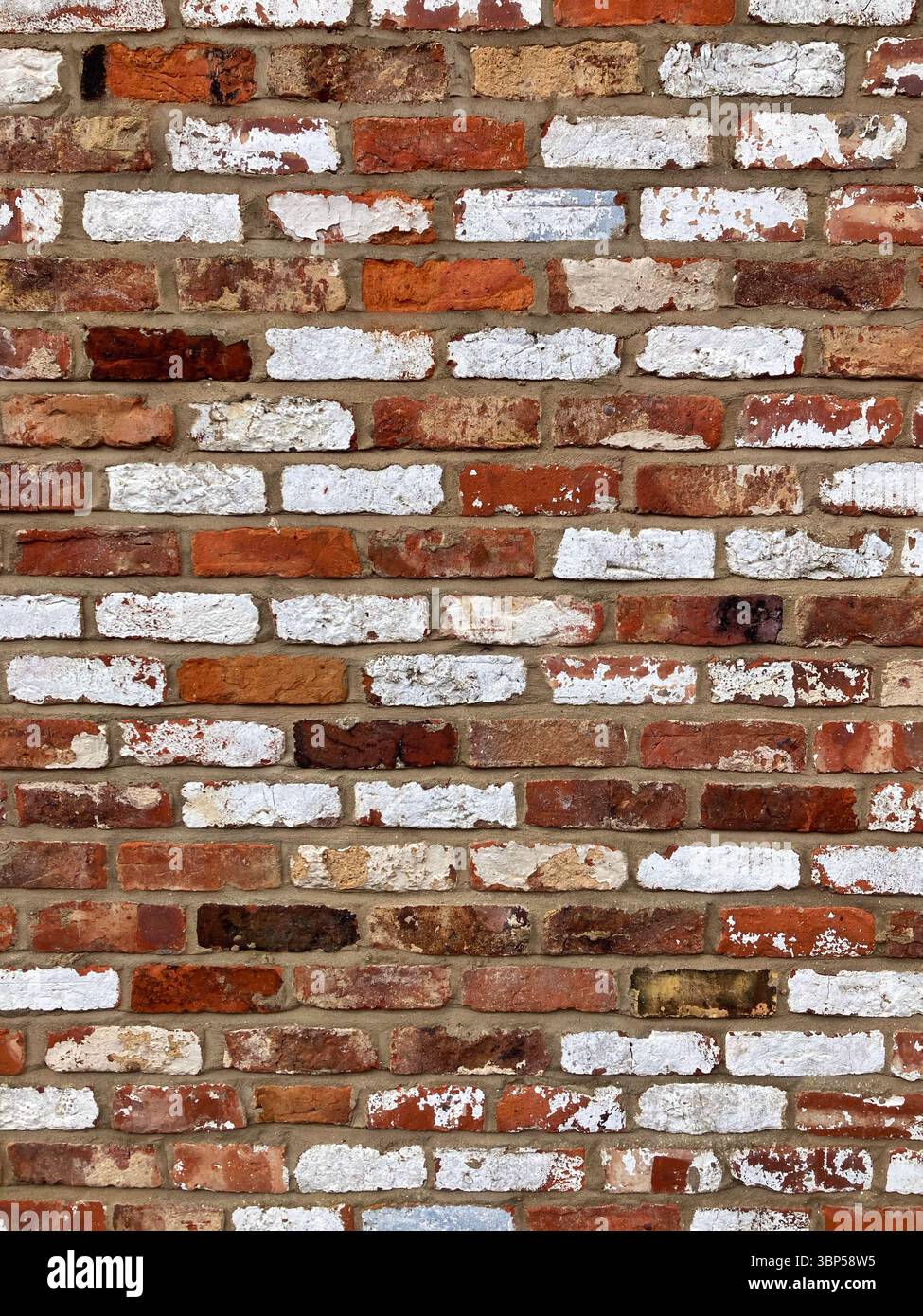 close up full frame red brick wall some painted white brickwork background Stock Photo