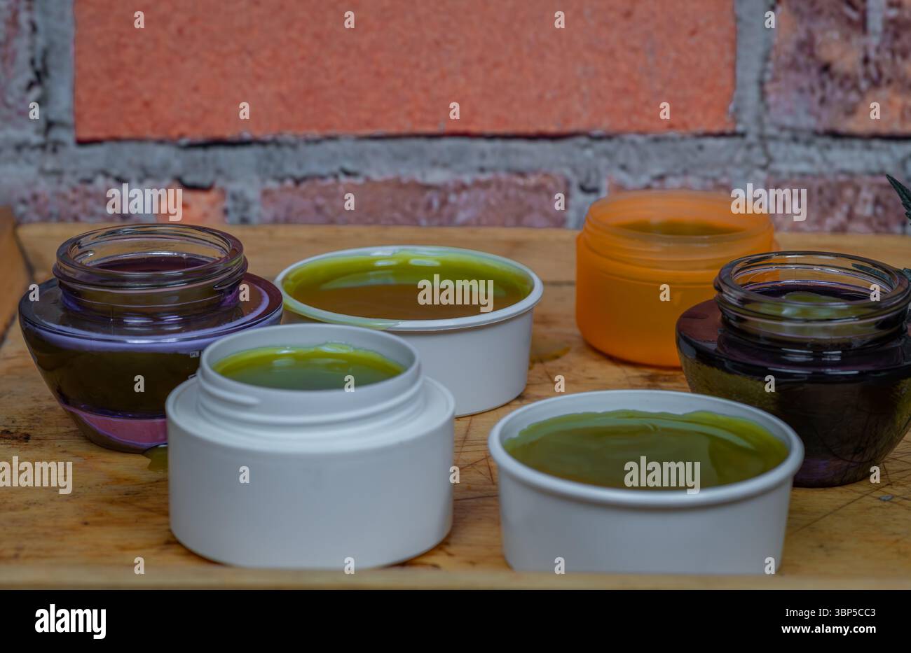 Home made marijuana medical salve with color brick wall indoor Stock Photo