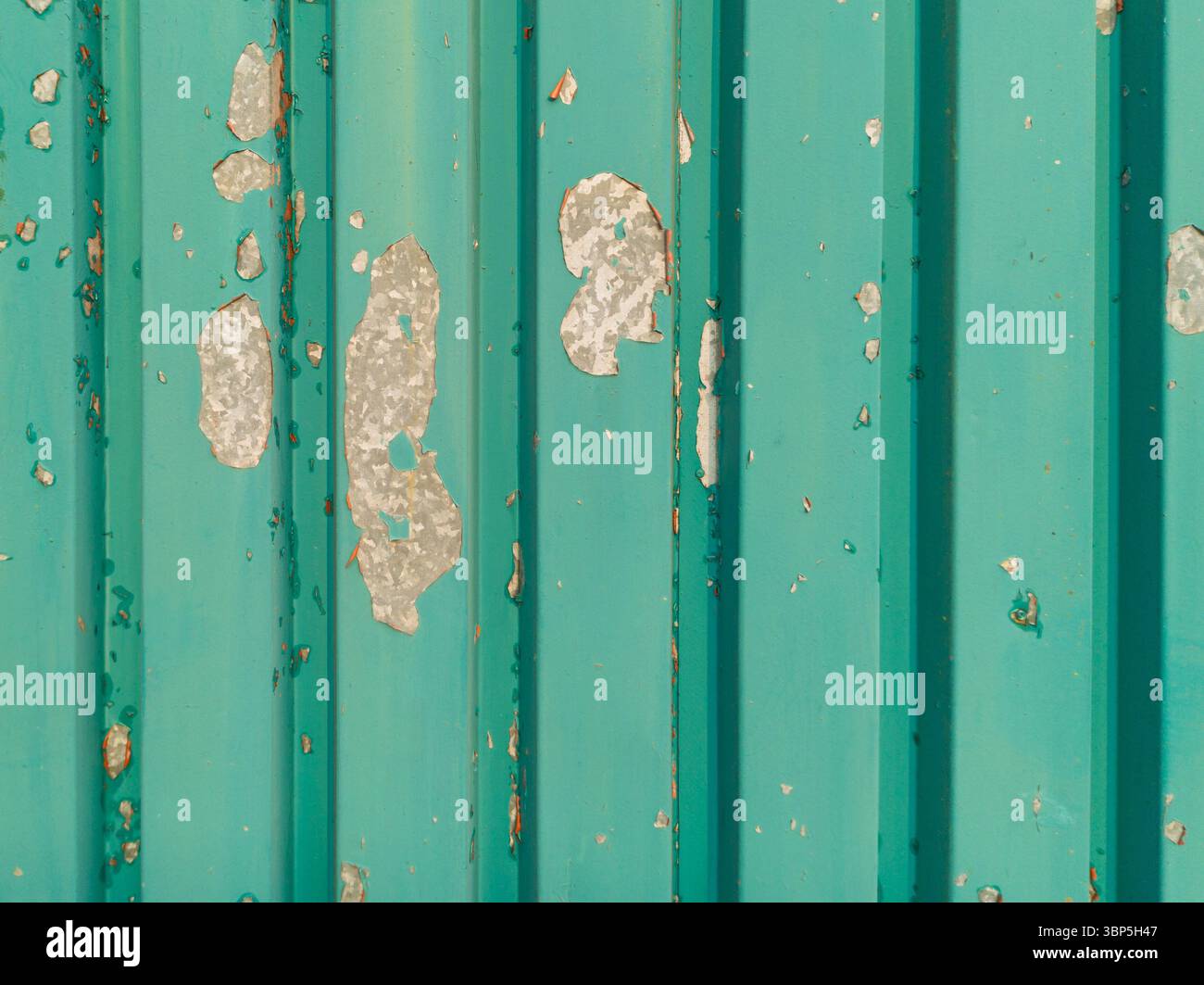 Peeling turquoise paint on metal wall Stock Photo