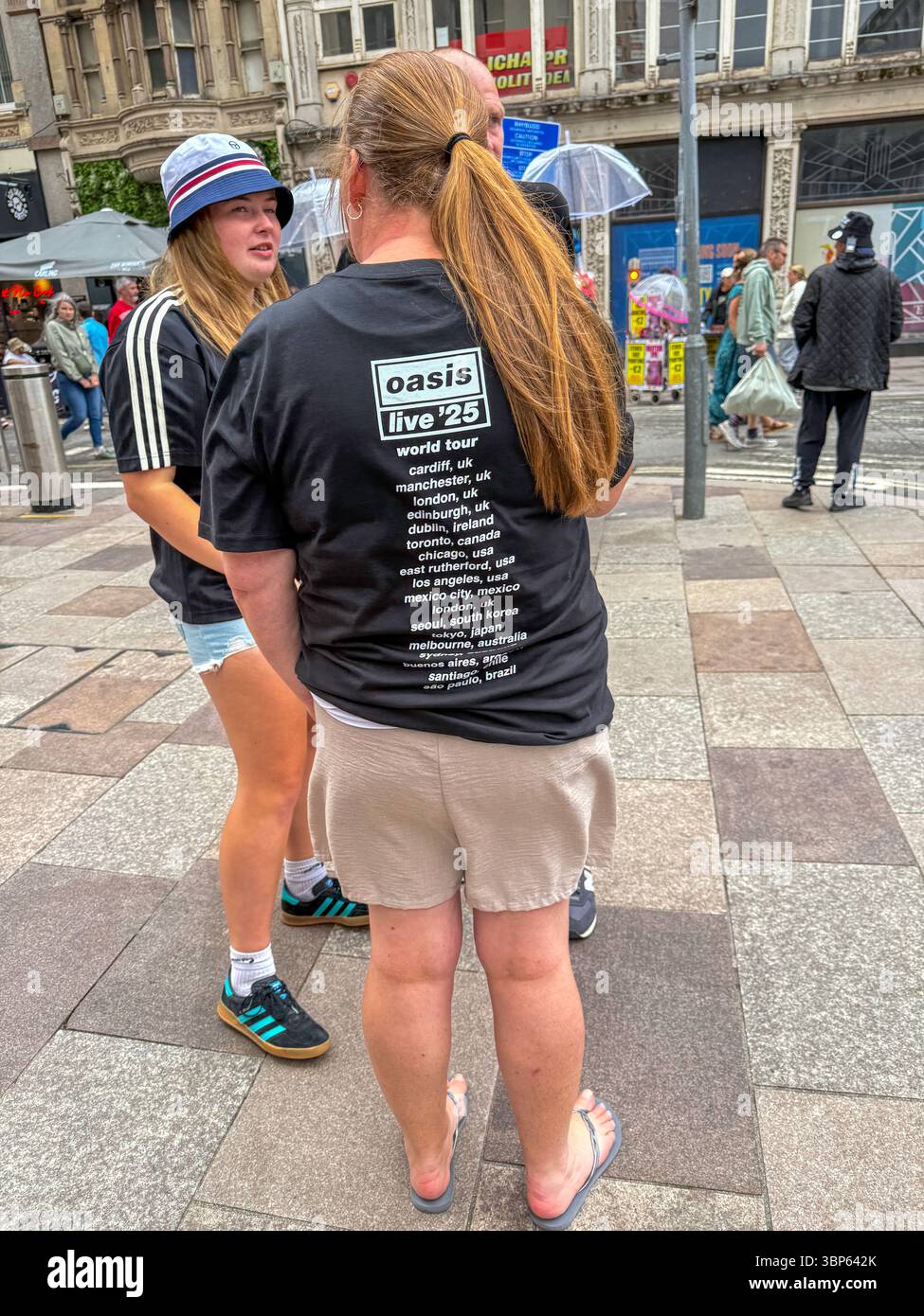 Oasis Fans and Buskers in Cardiff City Centre During Oasis Live ’25 Reunion Tour - Smartphone Captured Stock Image