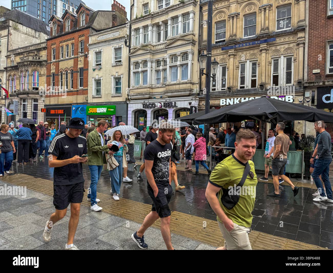 Oasis Fans and Buskers in Cardiff City Centre During Oasis Live ’25 Reunion Tour - Smartphone Captured Stock Image