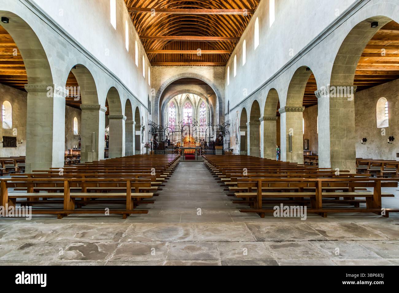 Rows of wooden pews lead the eye down the nave of St Mary and St Mark's Minster in Mittelzell, Reichenau, Baden-Württemberg, Germany, towards the Baroque choir screen. Overhead, the barrel-shaped Norman roof truss dates from 1236/37. It has only been open to view again since 1970. The minster belongs to the abbey's UNESCO World Heritage Site. Stock Photo