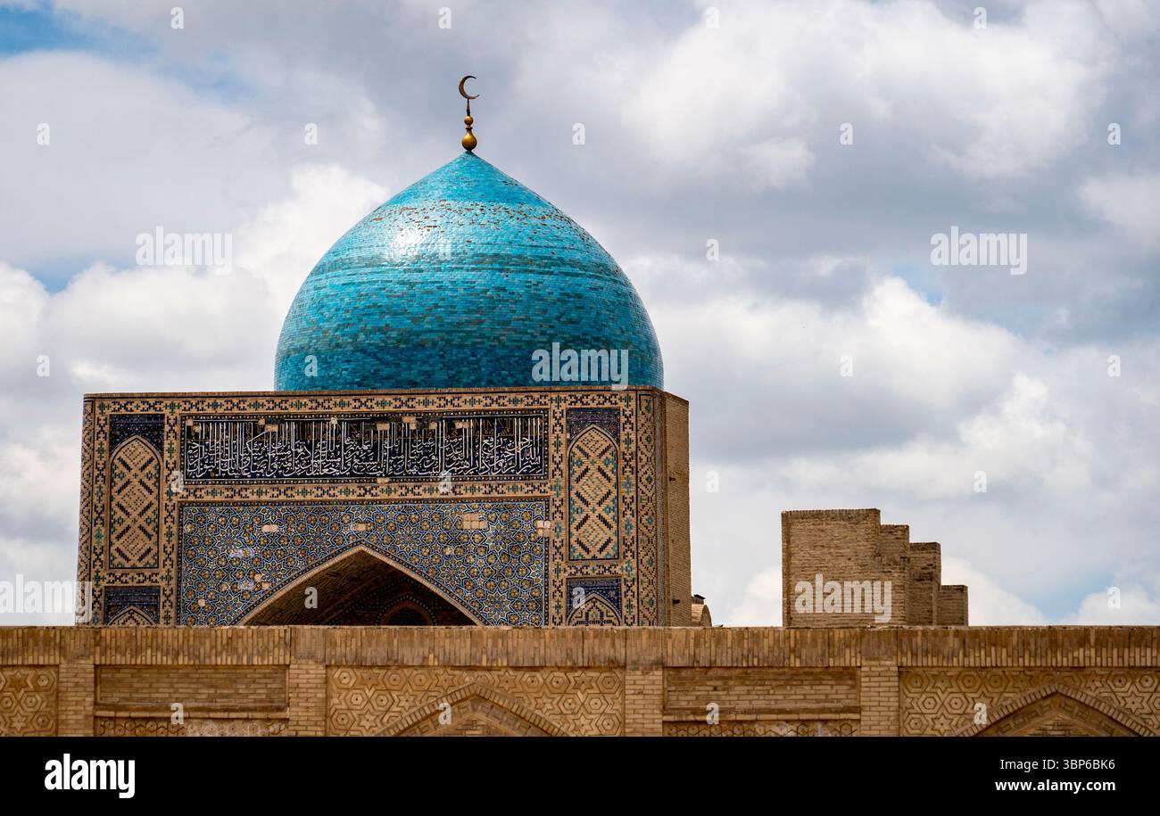 A stunning blue dome with intricate tile work, set against a backdrop of fluffy clouds. The dome is part of an ancient architectural structure, showca Stock Photo