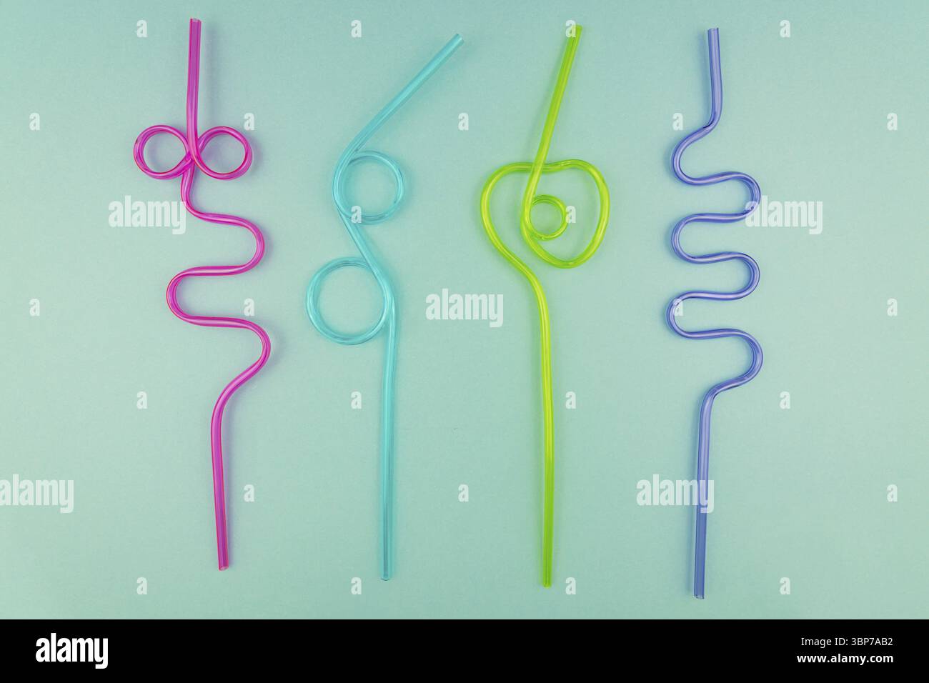 Multicolored plastic cocktails straws on blue background Stock Photo