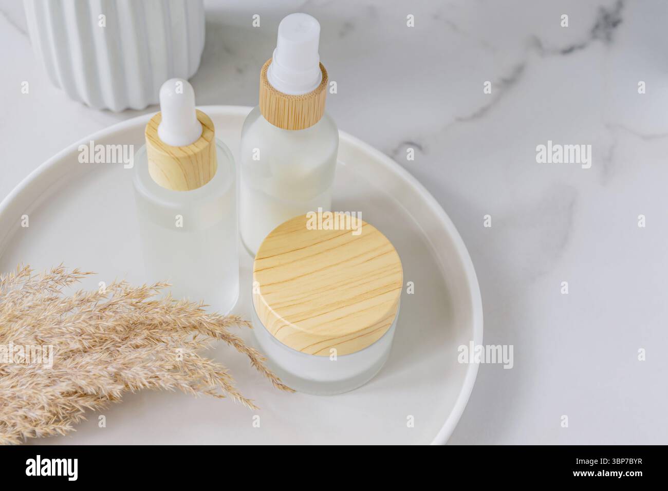 Naturkosmetik-Set auf einem Zerealientablett mit trockenem Pampasgras-Bouquet. Dekor im skandinavischen Stil. Nordische Kosmetik Stock Photo
