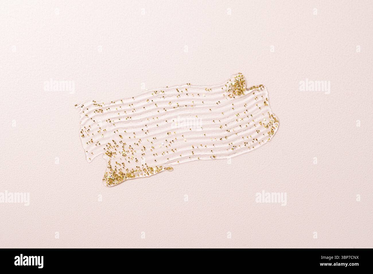Verschmierte Textur aus goldglaenzendem Glitzergel auf pastellfarbenem Hintergrund. Beispiel Textur Stock Photo