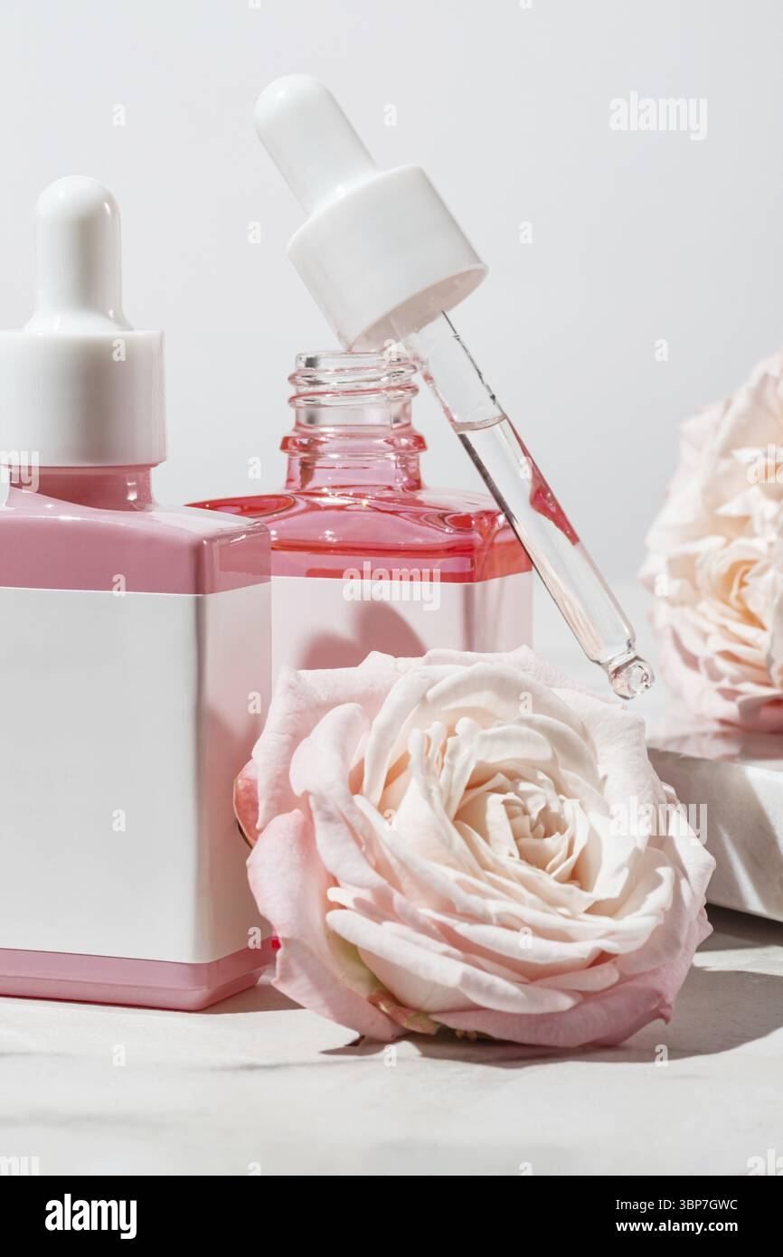 Kosmetikset fuer die Hautpflege in mit Rosenblueten verzierten Tropfflaschen. Ungebrandete Etiketten fuer Ihr Design Stock Photo