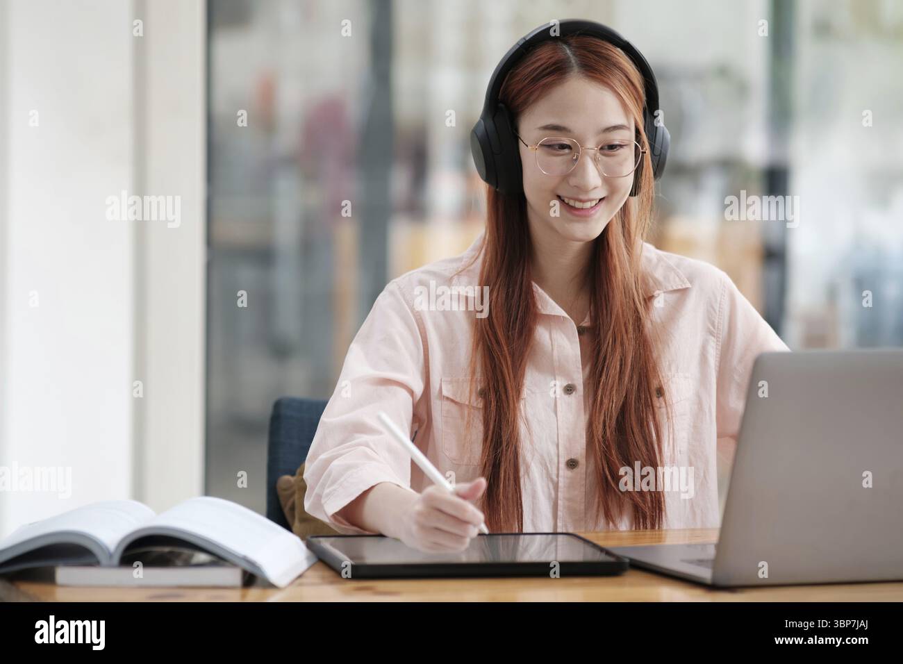 Young collage student using computer and mobile device studying online. Education and online learning Stock Photo